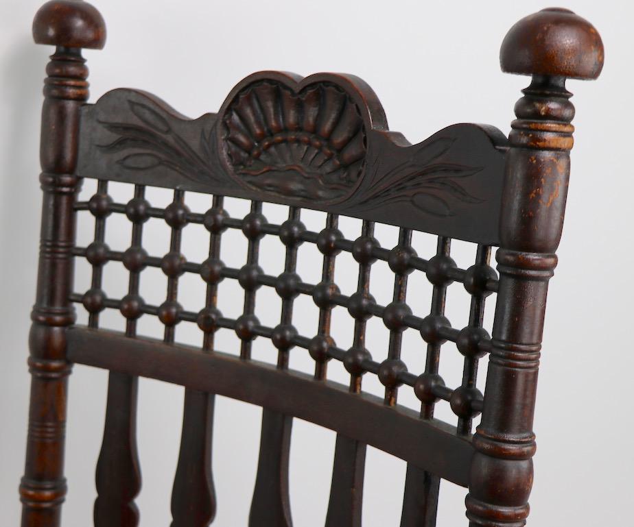 Stylized 19th century oak rocker attributed to Merklen Brothers having carved shell, stick and ball and banister back details. Exaggerated ball tops, and hand grips finish this Classic architecturally inspired from. Although traditional in overall