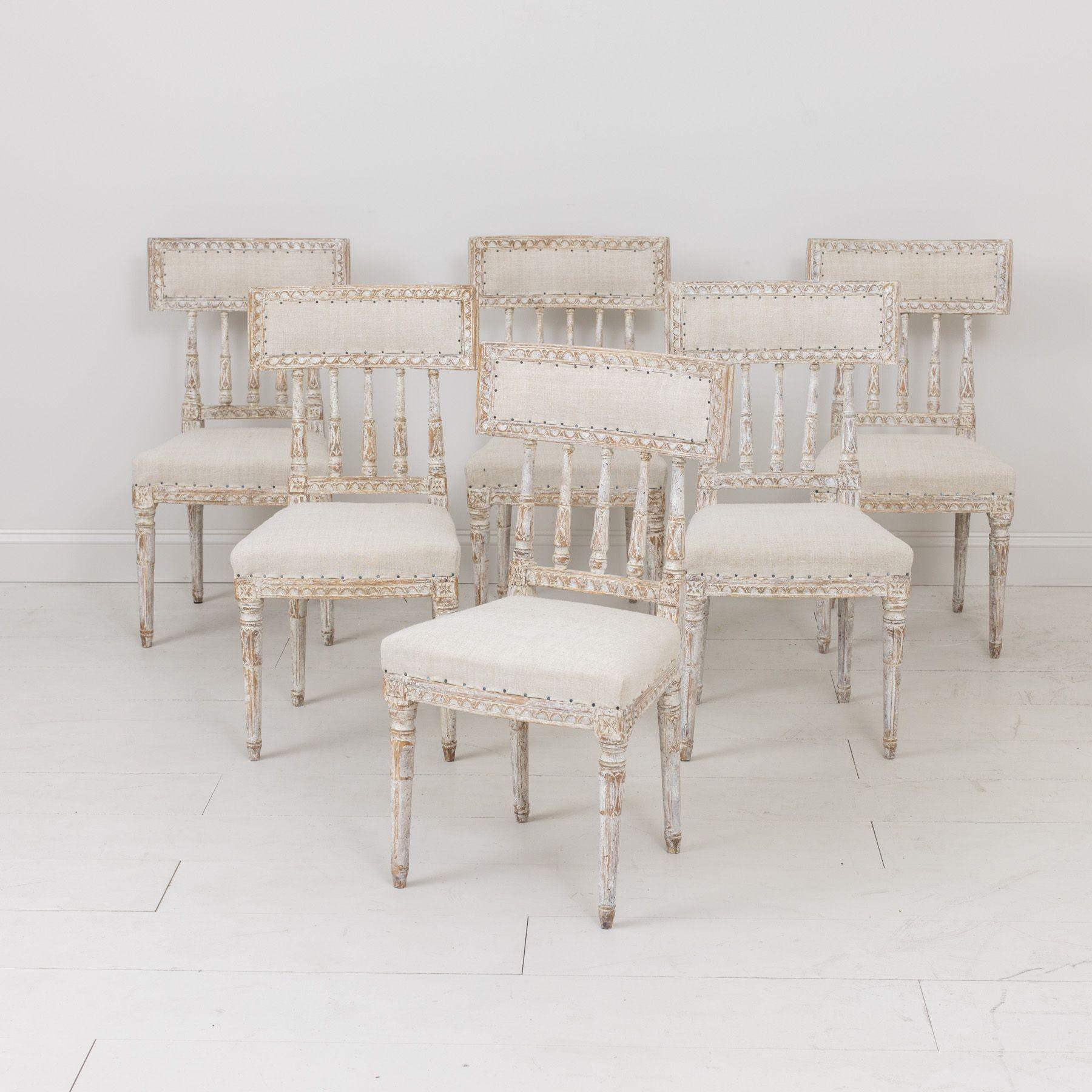 A set of six Swedish chairs from the Gustavian period in original ivory / taupe / gray paint, newly upholstered in antique linen. These beautiful chairs have curved splat backs, inspired by antique Roman 