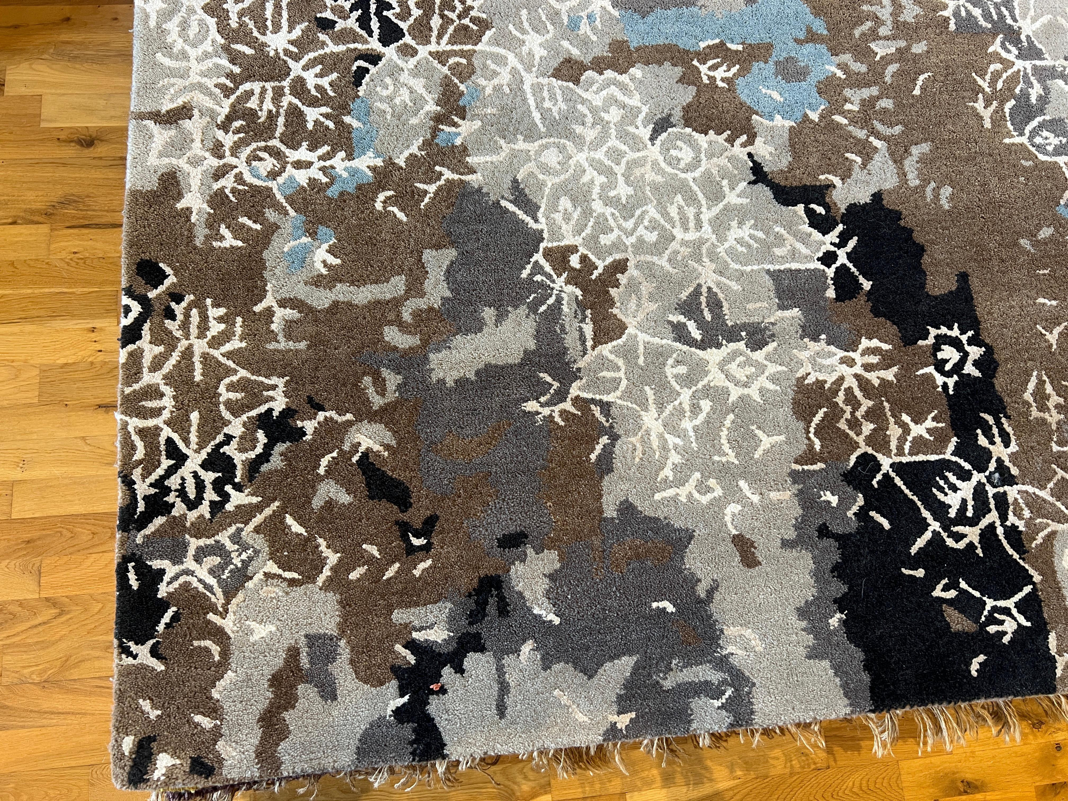 Elevate your space with our unique 9'x12' Deconstructed Floral Design Rug. Hand-knotted in India with all wool, this rug showcases a beautiful mix of browns and blues. Add warmth and style to your home with this premium quality piece.