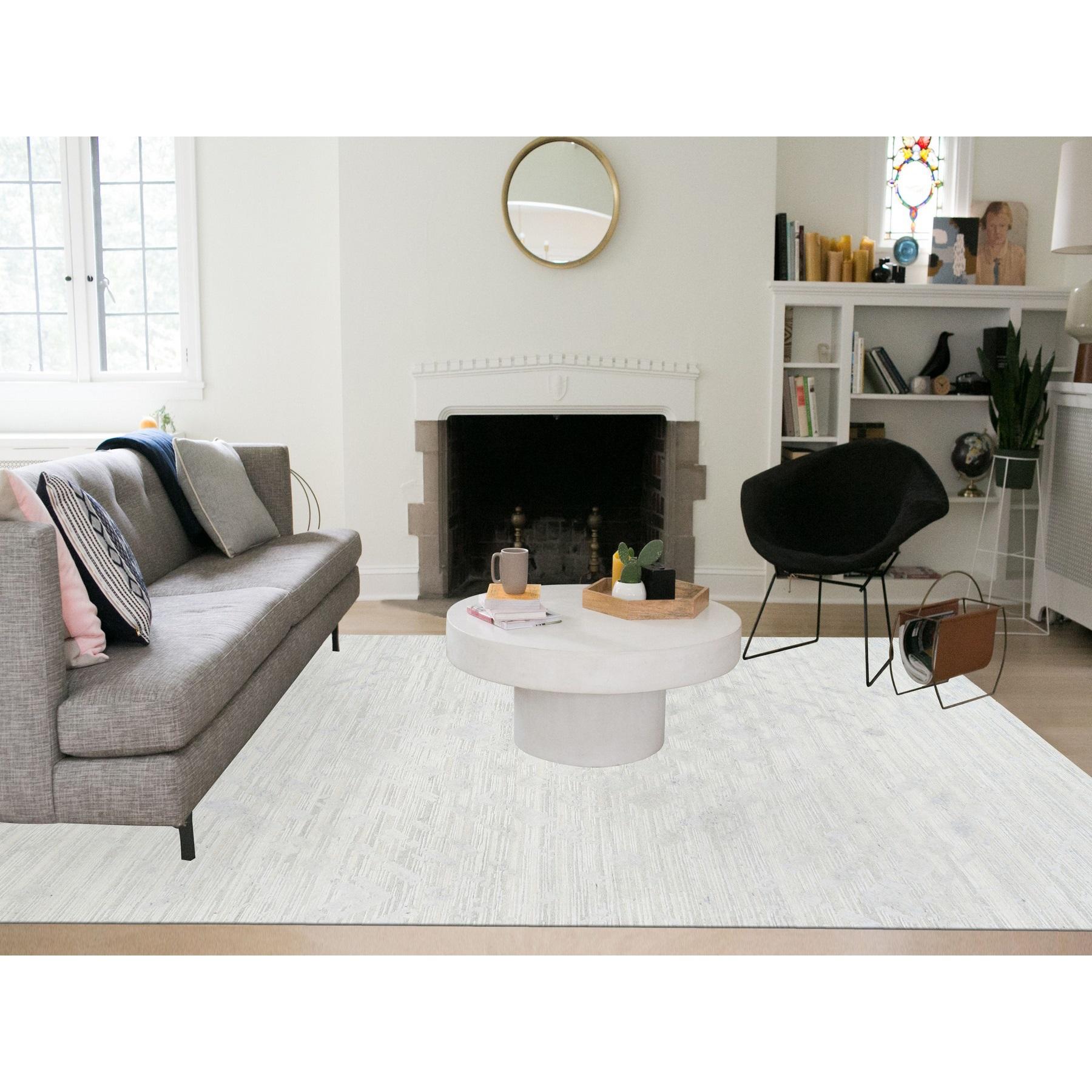 Il s'agit d'un véritable tapis d'Orient moderne en laine naturelle non teintée, filée à la main, nouée à la main, avec des poils gris clair coupés et bouclés. Il a été noué pendant des mois et des mois selon les techniques séculaires du tissage