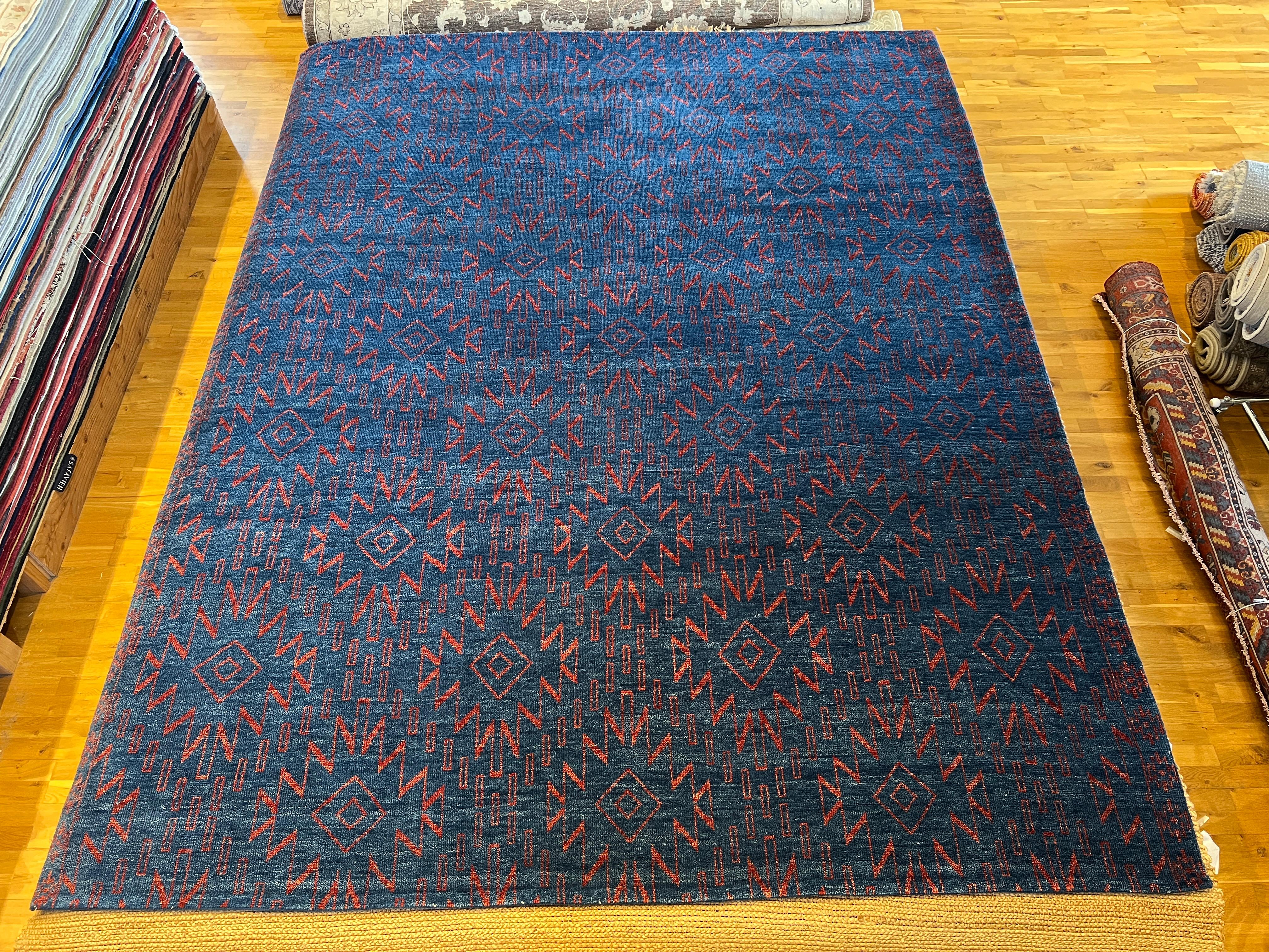 Verleihen Sie Ihrem Zuhause mit unserem marokkanischen Teppich 9'x12' einen Hauch von modernem Stammesstil. Der leuchtend blaue Hintergrund und der rote Akzent sind ein Blickfang in jedem Raum. Dieser weiche und strapazierfähige Teppich wird Ihren