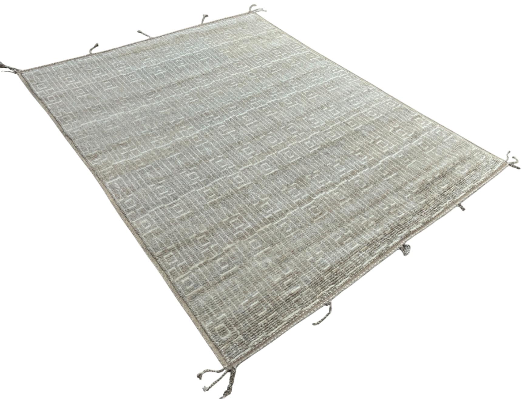 Eleva tu espacio vital con el exquisito encanto de esta nueva y moderna alfombra de diseño bereber marroquí Beni Ourain anudada a mano, elaborada con precisión y cuidado a partir de 100% lana. Combinando el encanto del estilo marroquí con la