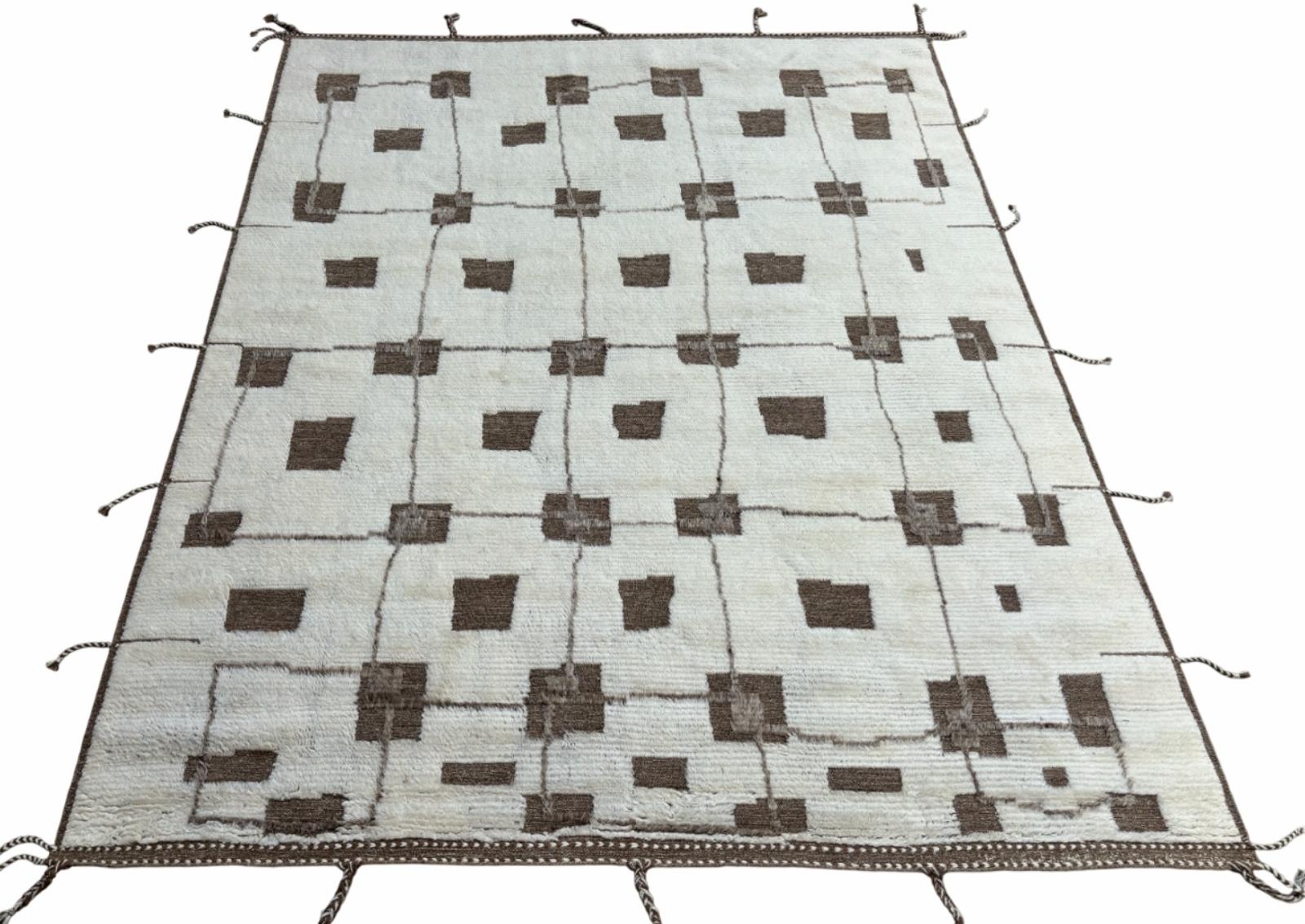 Eleva il tuo spazio abitativo con il fascino squisito di questo nuovo tappeto moderno annodato a mano dal design berbero marocchino Beni Ourain, realizzato con precisione e cura in lana al 100%. Combinando il fascino dello stile marocchino con la