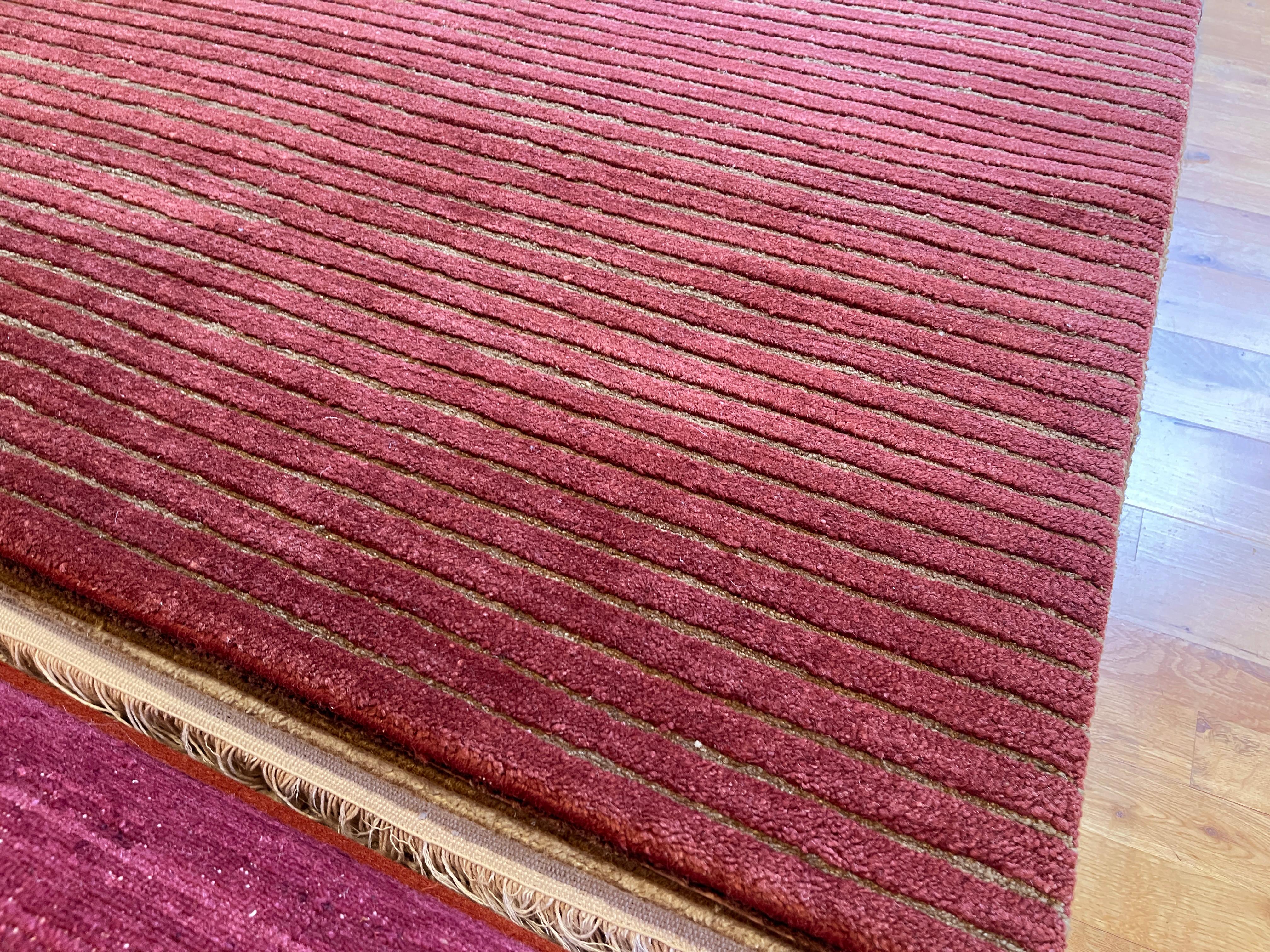 Rot und Tan geripptes Design

Verschönern Sie Ihr Zuhause mit diesem atemberaubenden, handgeknüpften Wollteppich mit einem satten, rot- und hellbraunen Rippenmuster. Dieser in Nepal fachmännisch gefertigte Teppich aus reiner Wolle bietet sowohl