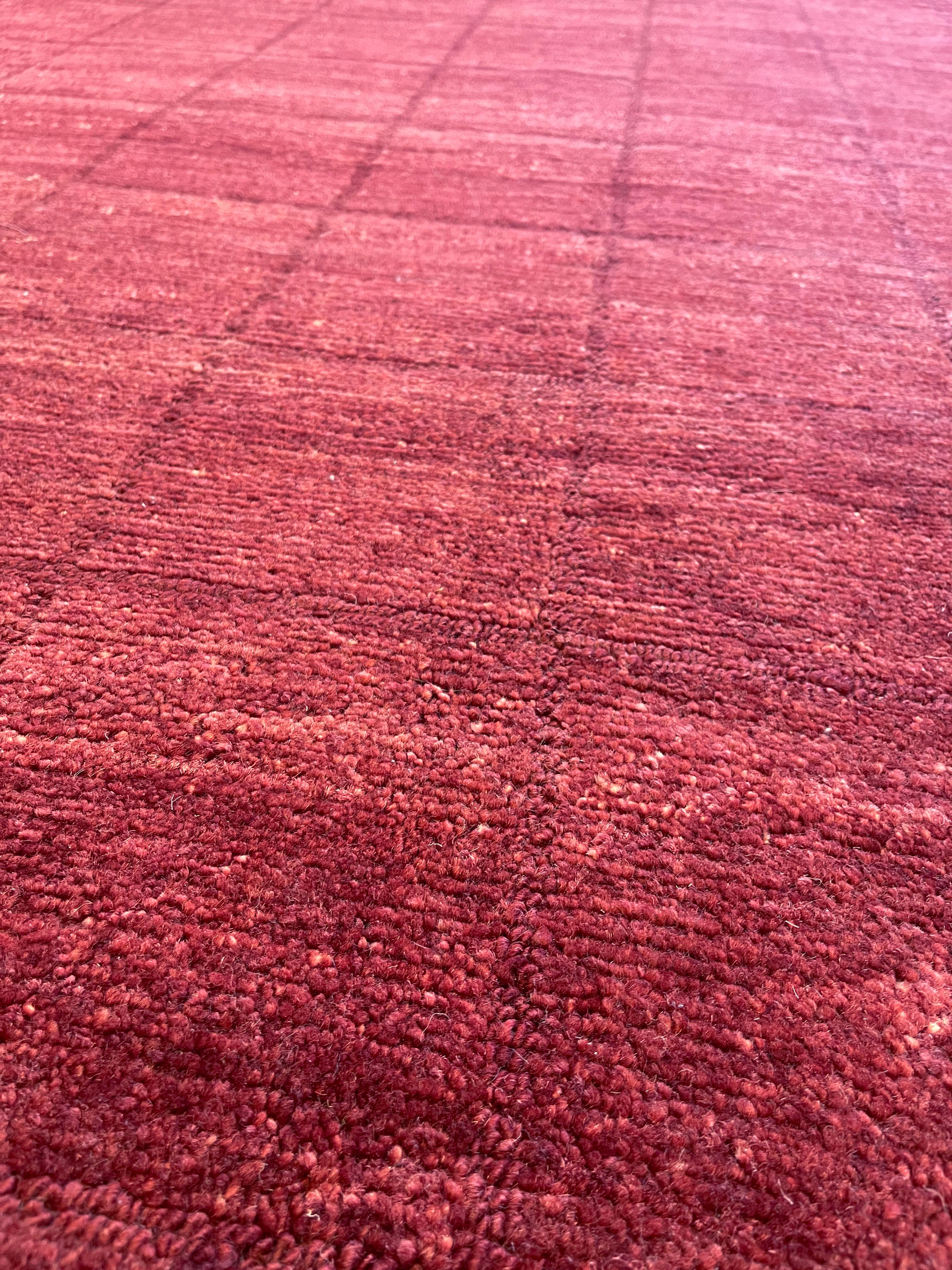
Verleihen Sie Ihrem Raum einen Hauch von Eleganz mit diesem exquisiten, handgeknüpften Wollteppich mit auffälligem roten Karomuster. Dieser in Nepal gefertigte Teppich aus reiner Wolle vereint Strapazierfähigkeit und Weichheit und eignet sich daher