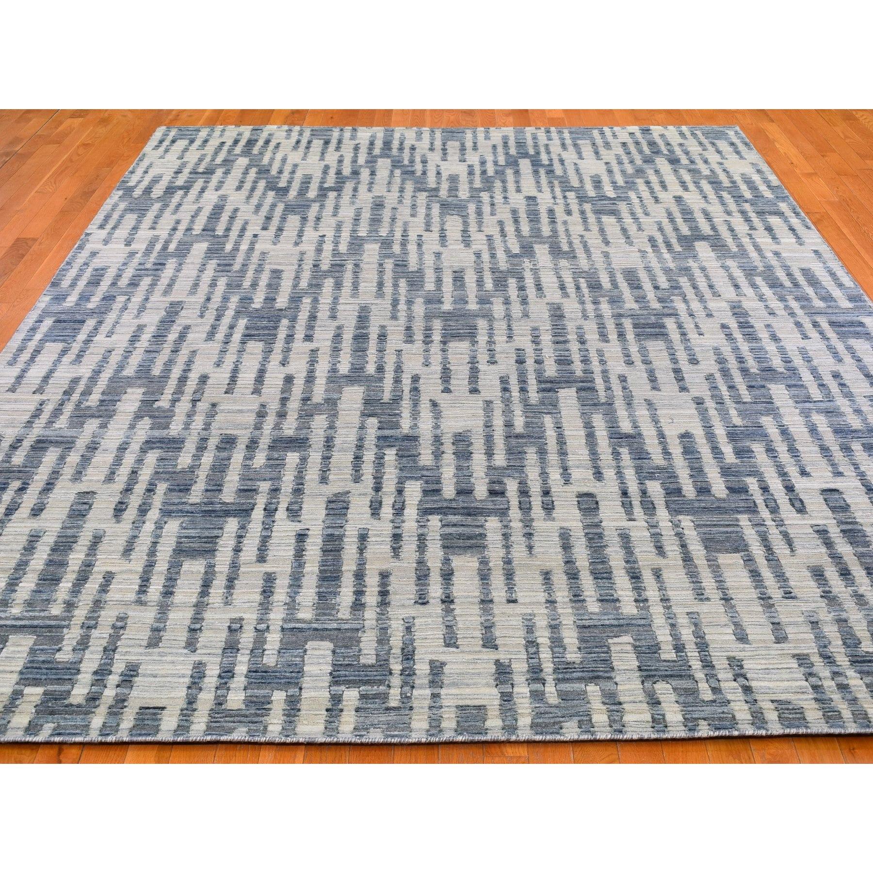Il s'agit d'un véritable tapis oriental noué à la main, unique en son genre, en pure soie bleue et laine texturée, avec des zigzags et un design graphique. Il a été tissé pendant des mois et des mois selon les techniques séculaires de l'artisanat