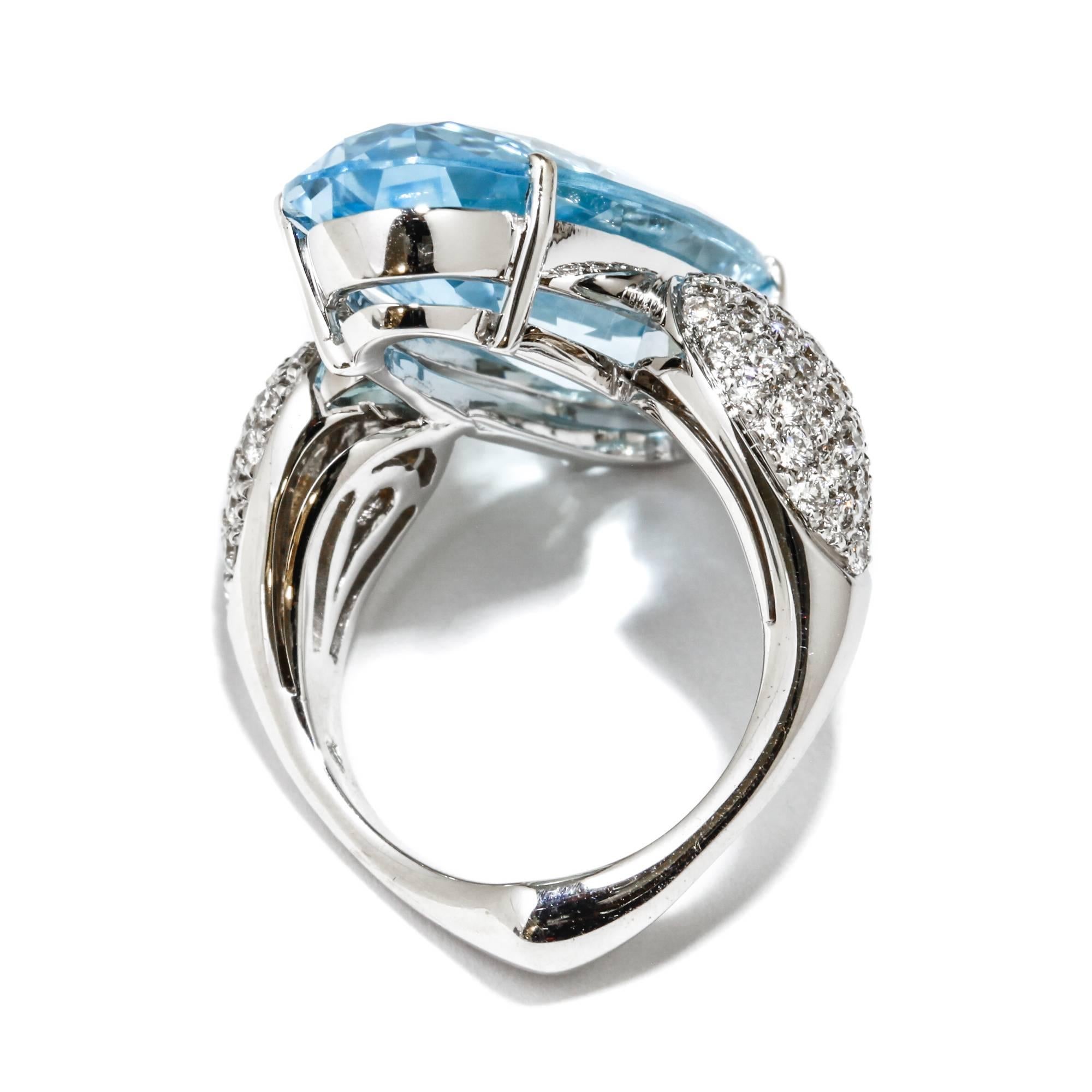 This A & Furst Fleur de Lys cocktail ring features a 19.50 ct. 28x12mm oval shaped blue topaz with 0.95 ct. pave-set round diamonds, set in 18k white gold. This ring is a size 6.5. If you need it to be sized, please message us with your finger size.