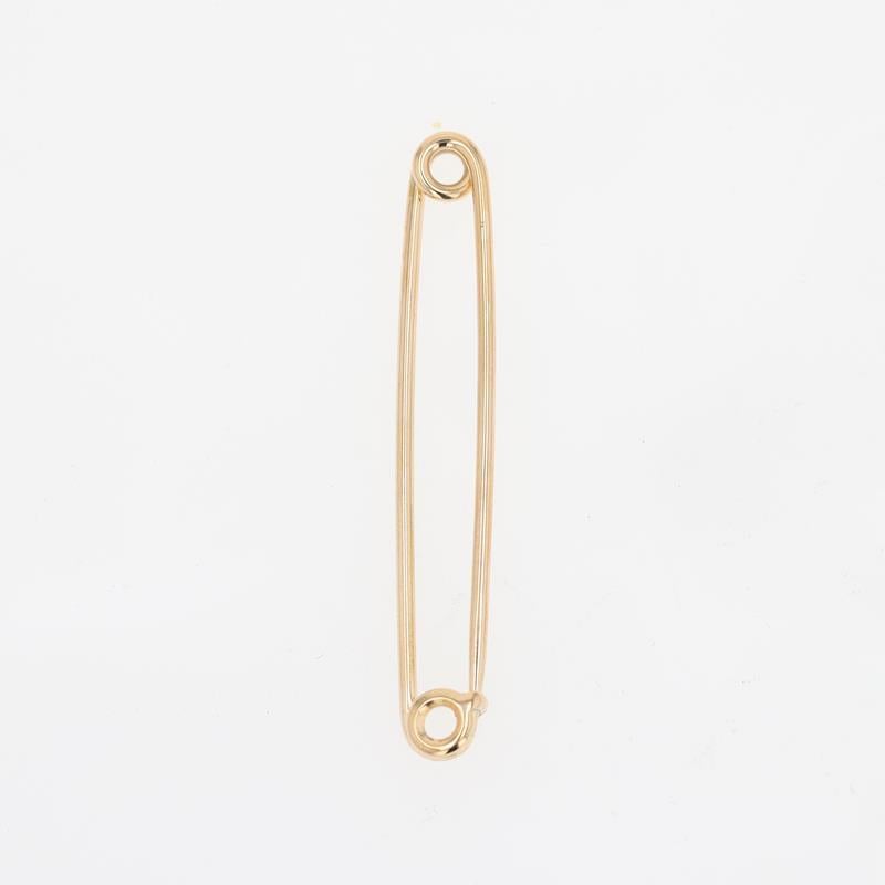 A 14 karat yellow gold safety pin signed Tiffany & Co. Fully functional and able to be used with attachments, this every day object rendered in precious metal by one of the world's foremost jewelry makers invites one to feel a sense of reverence for