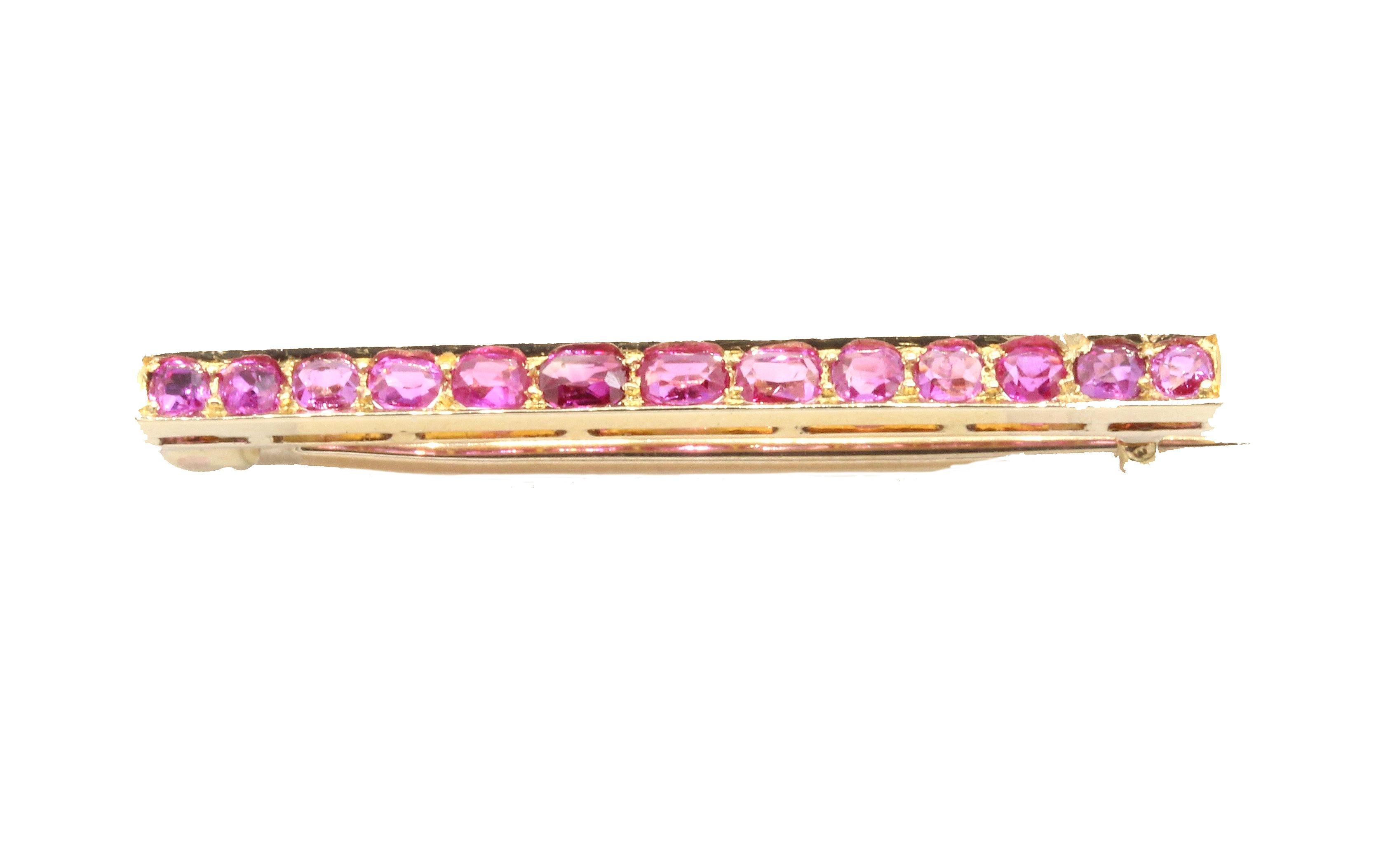 A 14 Kt Rose Gold & Ruby tie pin, with thirteen rubies set in a horizontal bar.