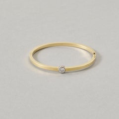 Un braccialetto in oro 14k con un singolo diamante