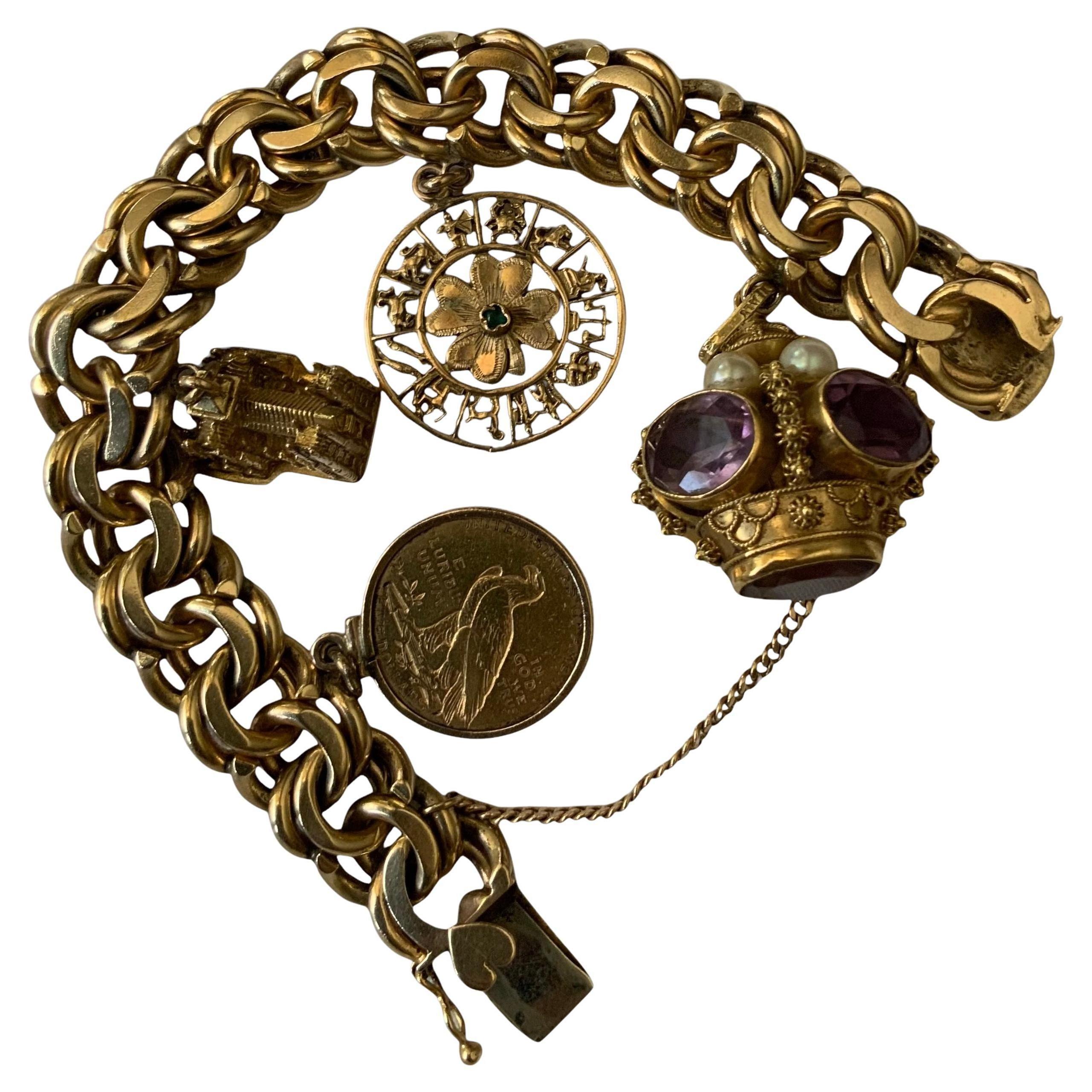 This is a 14K solid gold charm bracelet. It depicts a yellow gold double link chain bracelet with four gold charms. The charms are a Westminster  Abbey, a clover of four leaves surrounded by the zodiac signs, an Italian 750 gold Crown made of five