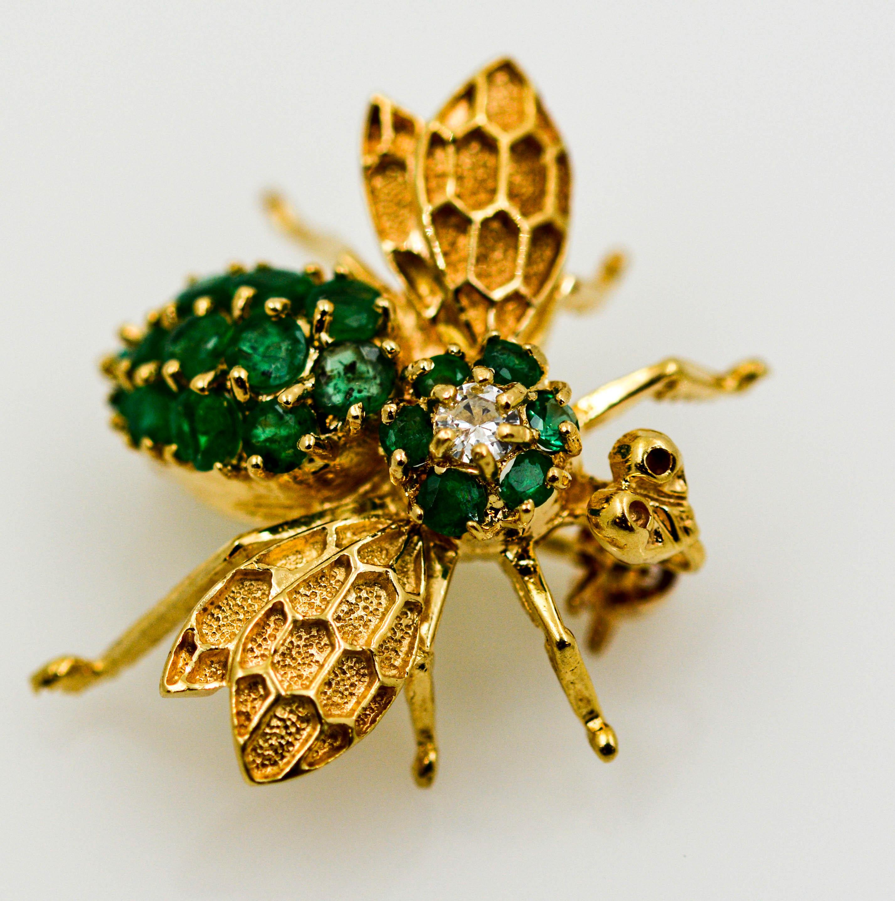 A 14kt yellow gold and emerald bee pin.  The body of this bee pin is set with 19 round emeralds that have an approximate combined weight of 0.50 carats.  The pin is also accented with a round brilliant cut diamond that weighs approximately 0.04