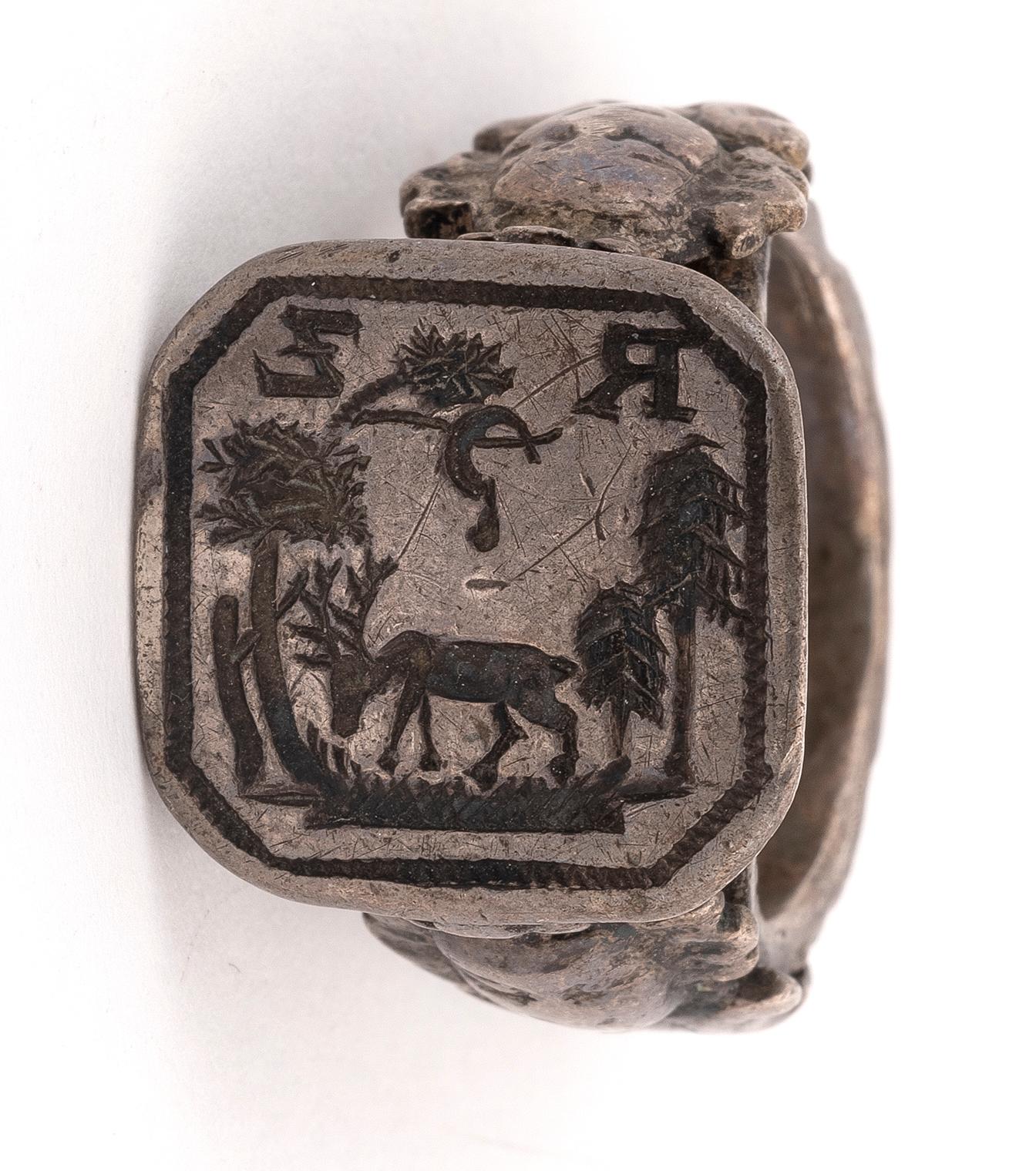 The silver ring with an octagonal plaque carved with merchant's symbols.
Ring size 8 1/4