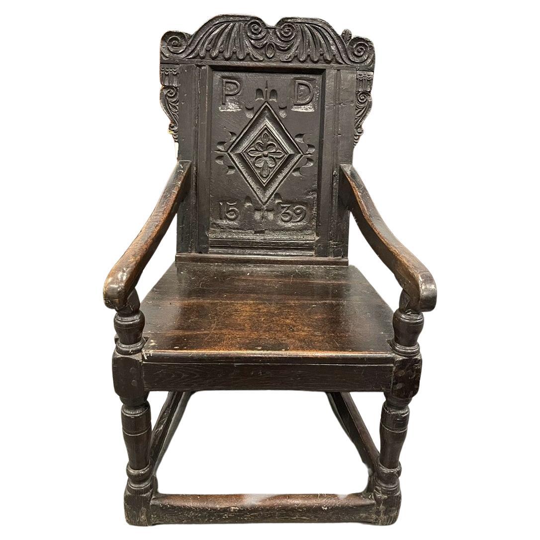 A 16th CENTURY OAK WAINSCOT CHAIR DATED 1539