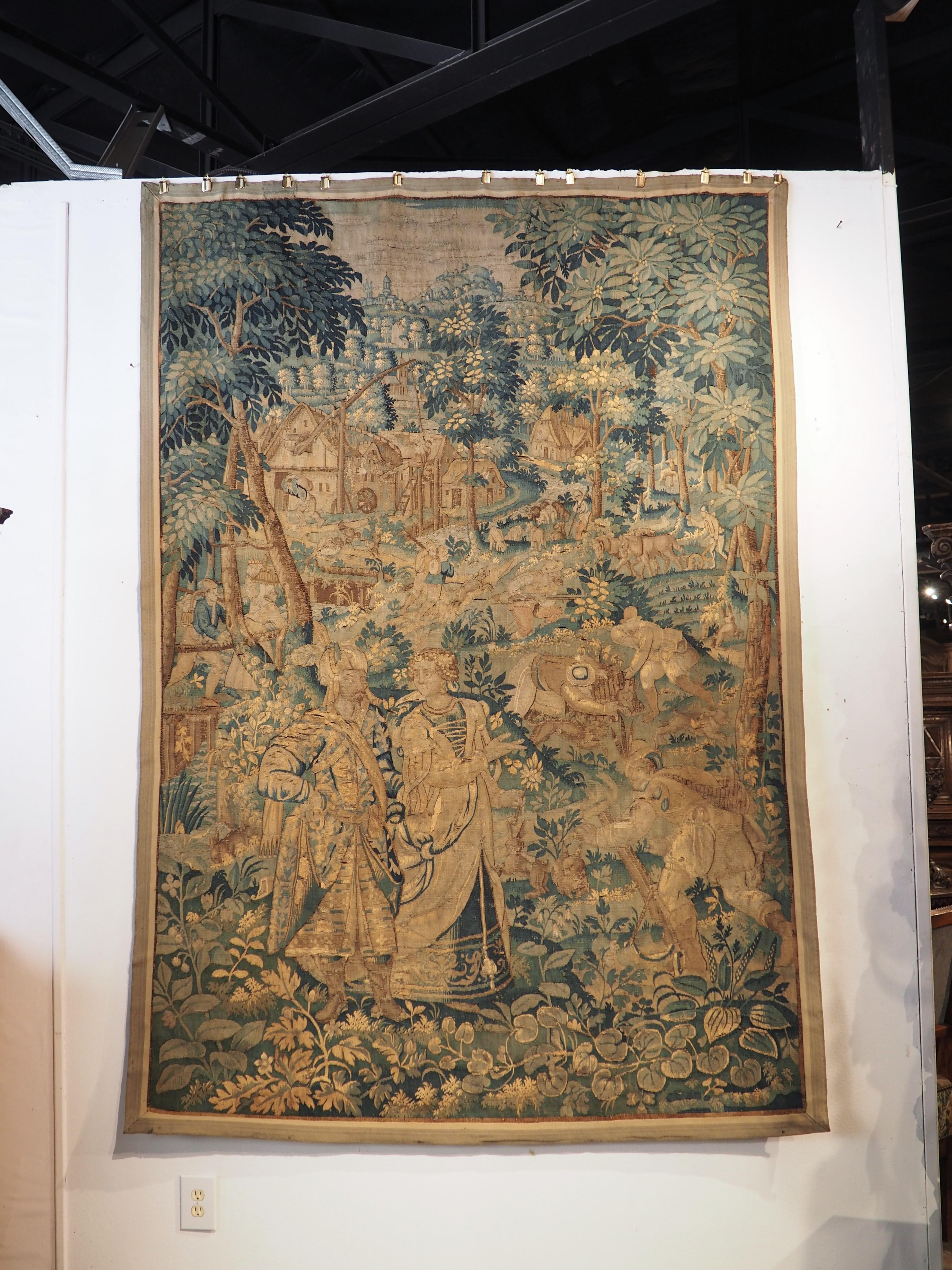 A beautiful verdure landscape with a story to tell, this tapestry was produced in Flanders in the 1500’s. The roughly 500 year old tapestry is comprised of silk and wool fibers that have been dyed green, brown, cream, and gold, with the occasional