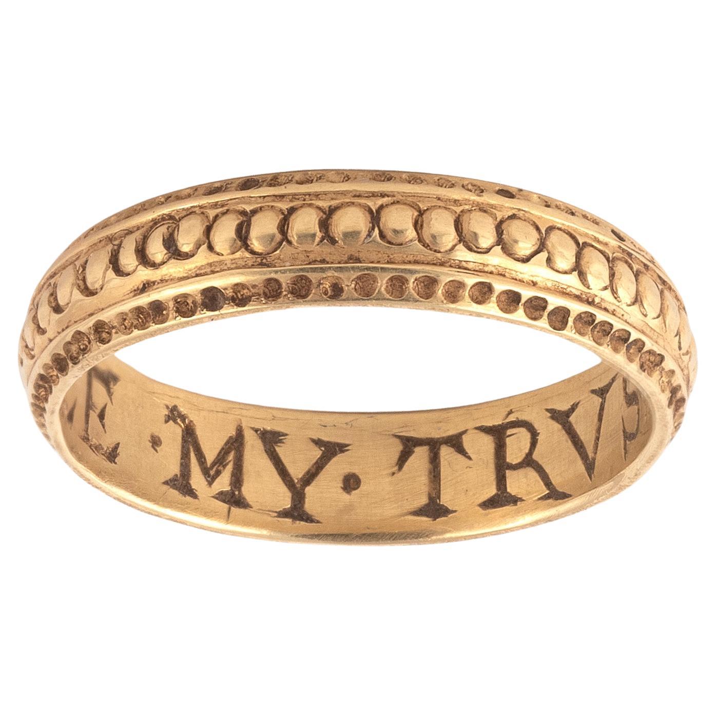 Late 17th century gold posy ring, engraved to the interior with the inscription 'Alle my trust' with engraved decoration to outer shank, size 7
Weight: 4,11gr.

“Posy rings,” their name deriving from the term poésie or poetry, are rings with mottoes