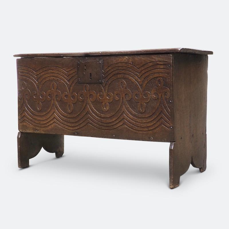 A 17th century English oak boarded chest, Charles I, circa 1640

An unusual Carolean chest from the mid-17th century distinctively carved with two waved bands of interlocking trefoils or fleur-de-lys. Unlike joined chests from this period this