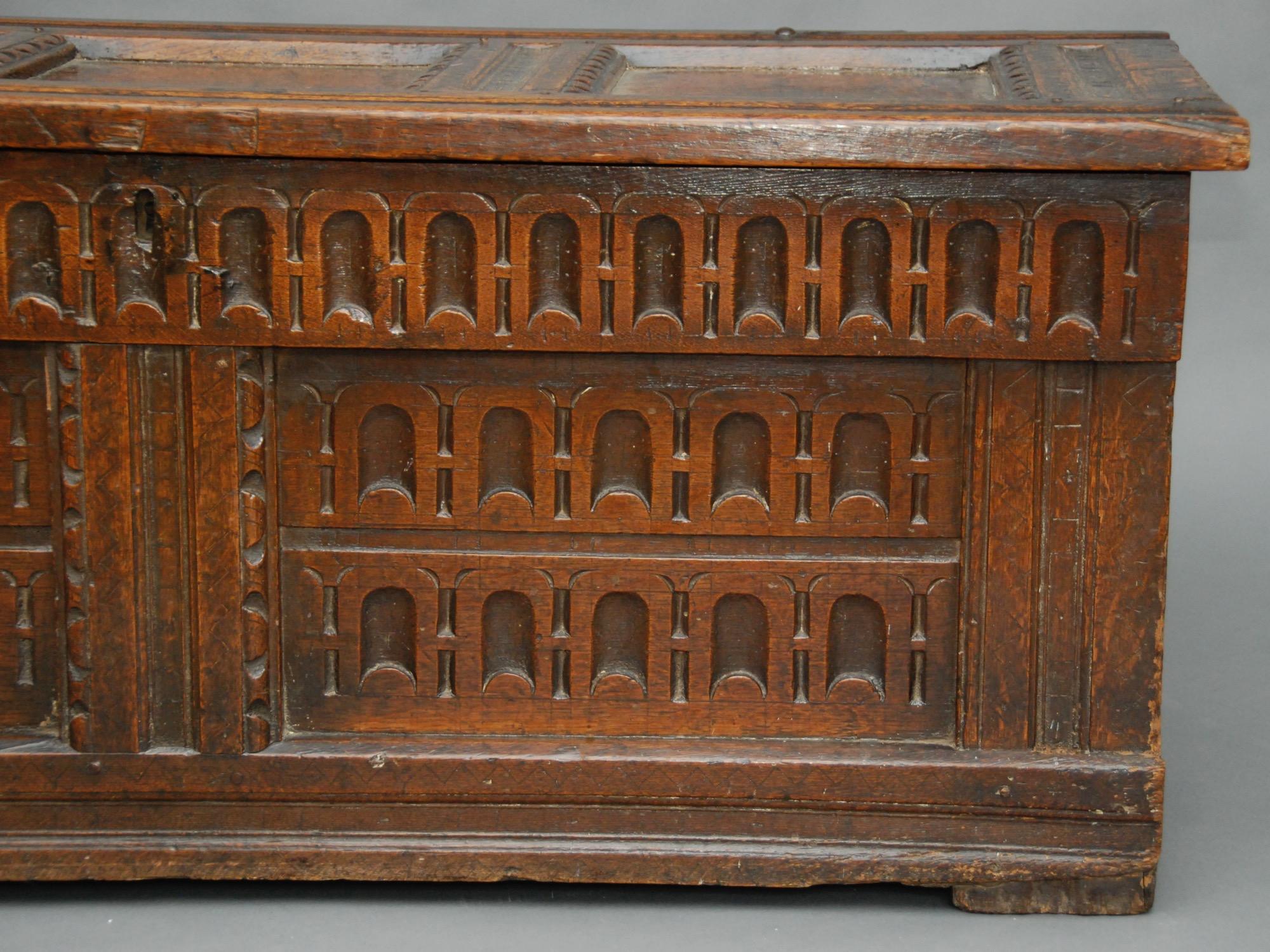 A 17th century oak chest with a triple paneled top having incised lozenges and the interior with remains of a shelf, the frieze and twin paneled front with arcaded carvings. This has a gorgeous patina!
