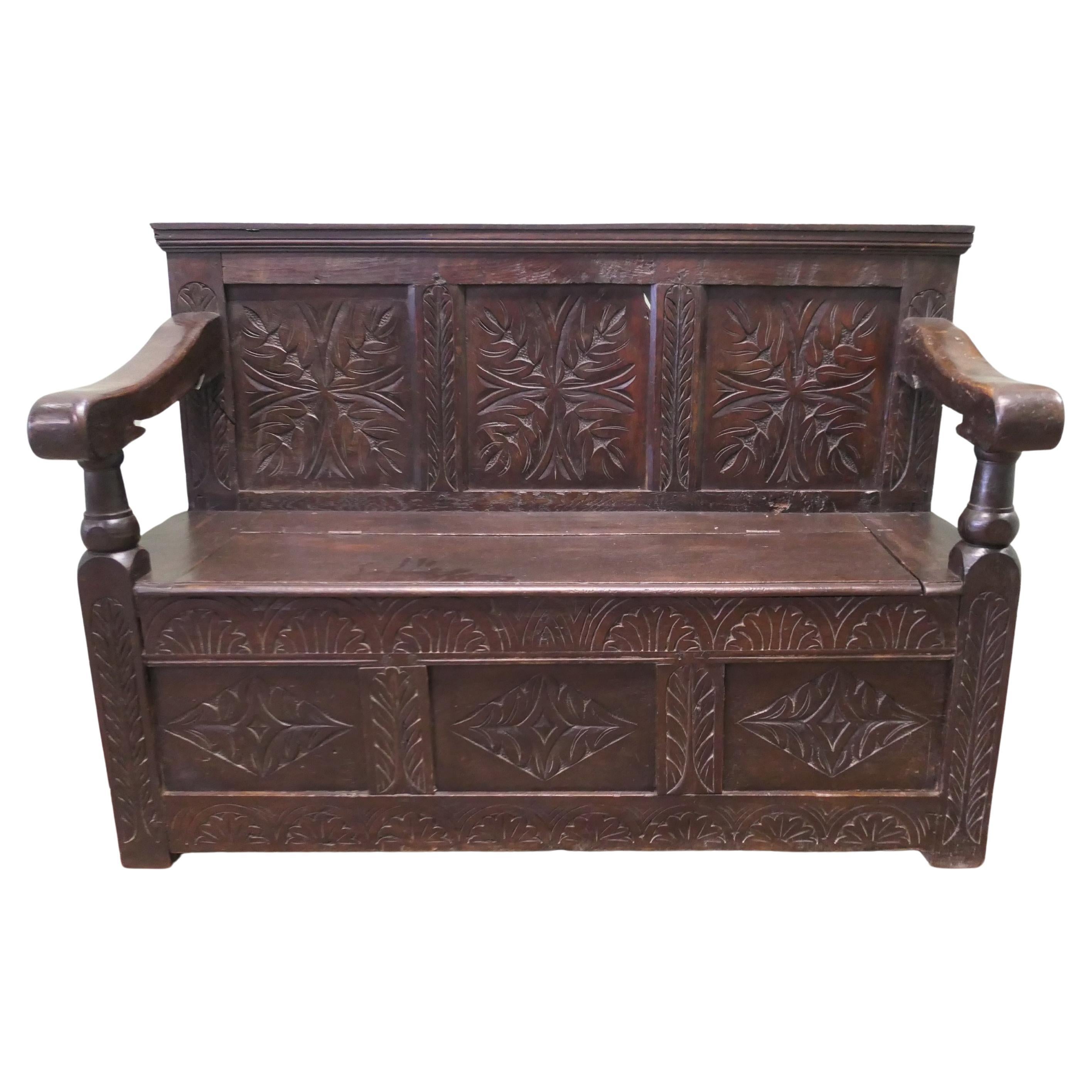 A 17th Century High Back Oak Box Settle   The Settle has 3 carved back panels