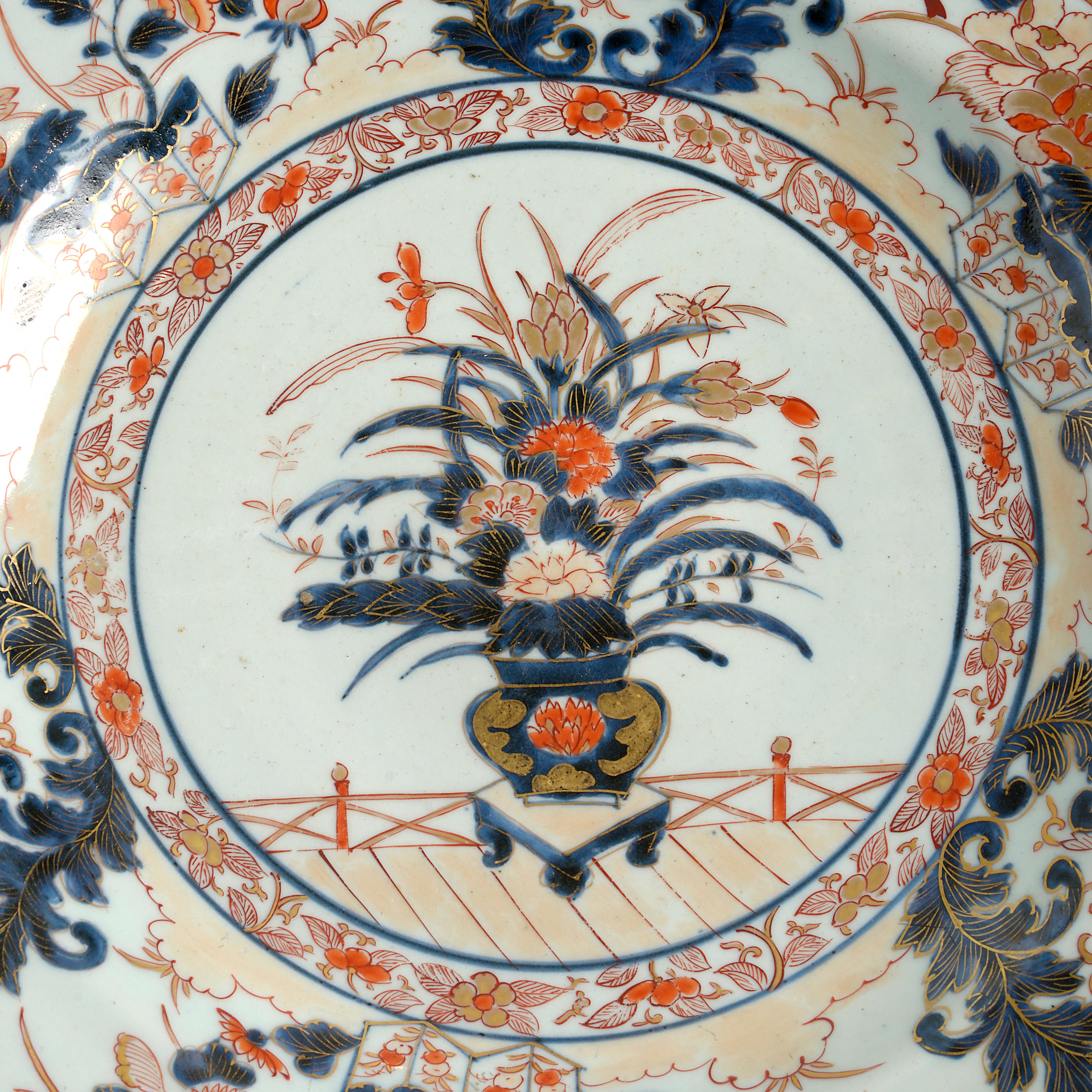 A late 17th century Imari Porcelain charger, decorated with red, blue and gilt glazes upon a white ground in the traditional manner, having a central floral still life cartouche within a foliate border.