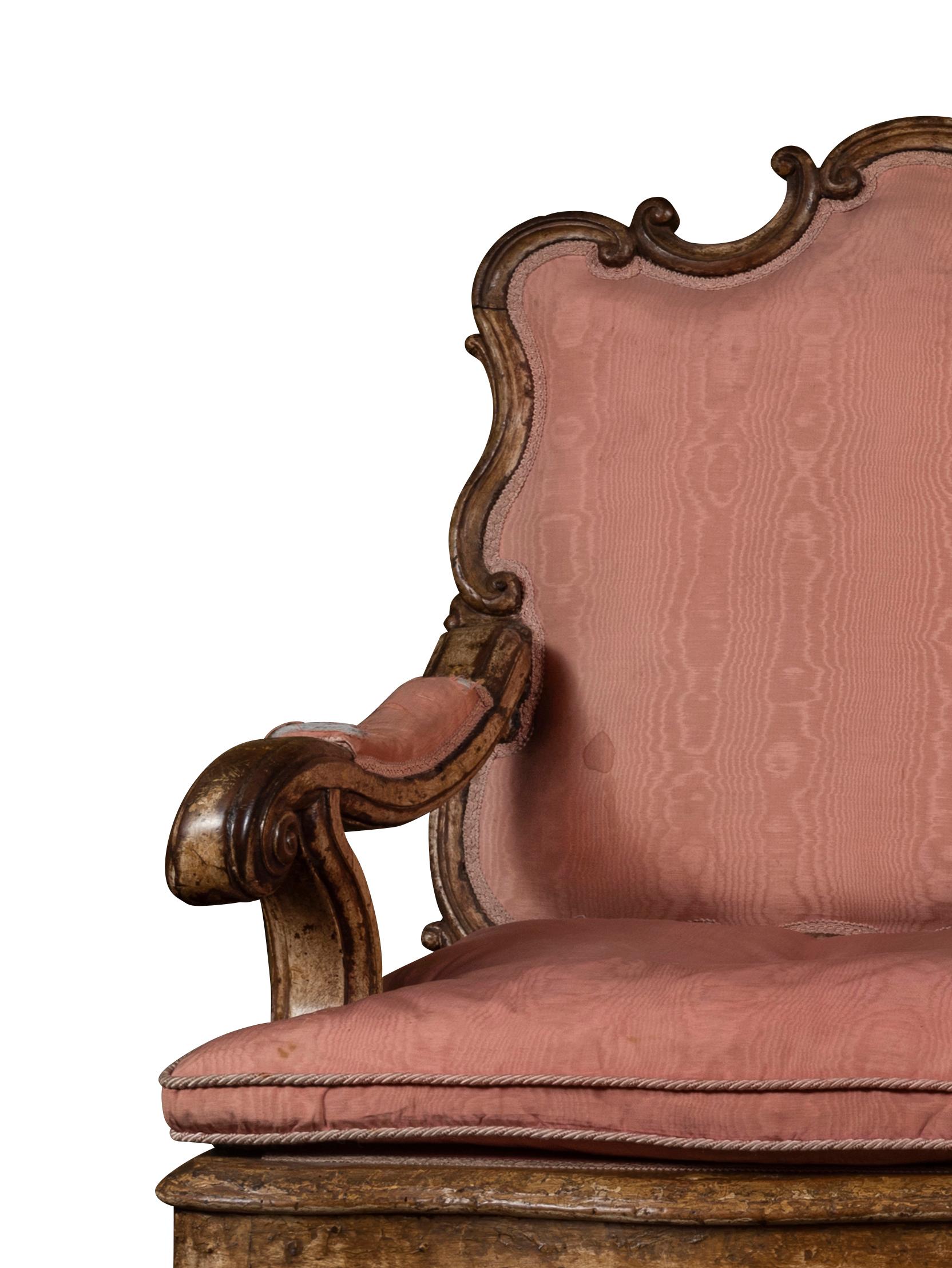 The 'C' and 'S' scroll frame rising to three conjoined cartouche back rests with cross hatched shaped terminals between, the scroll with padded arms supports, the manchettes, padded back and separate seat cushion upholstered in salmon moire silk,