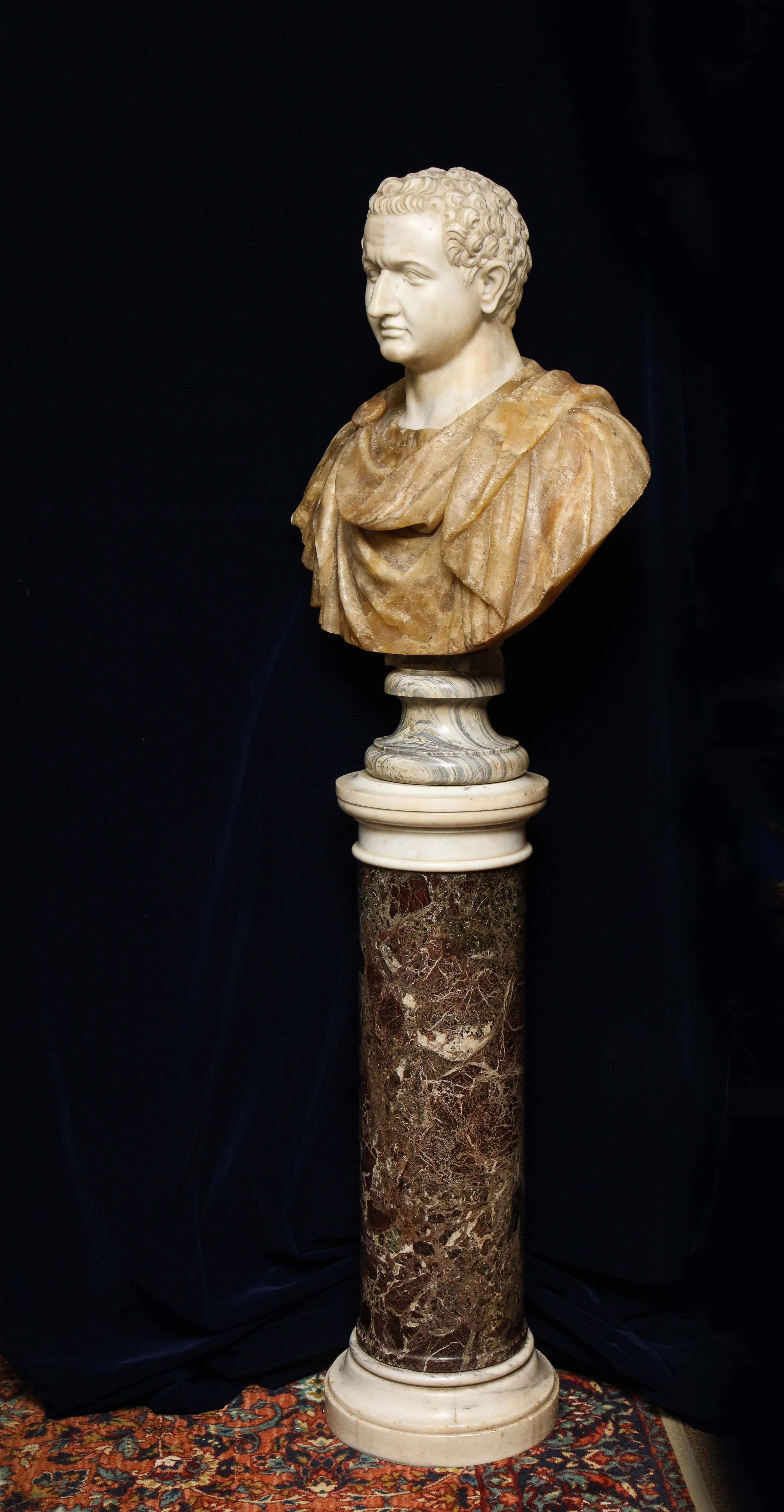 A striking late 18th-early 19th century bust of the Roman Emperor Titus Domitian. The head is made from hand carved white Carrara marble, the tunic and toga are made from hand carved honey alabaster, which are all supported on a cipollino marble