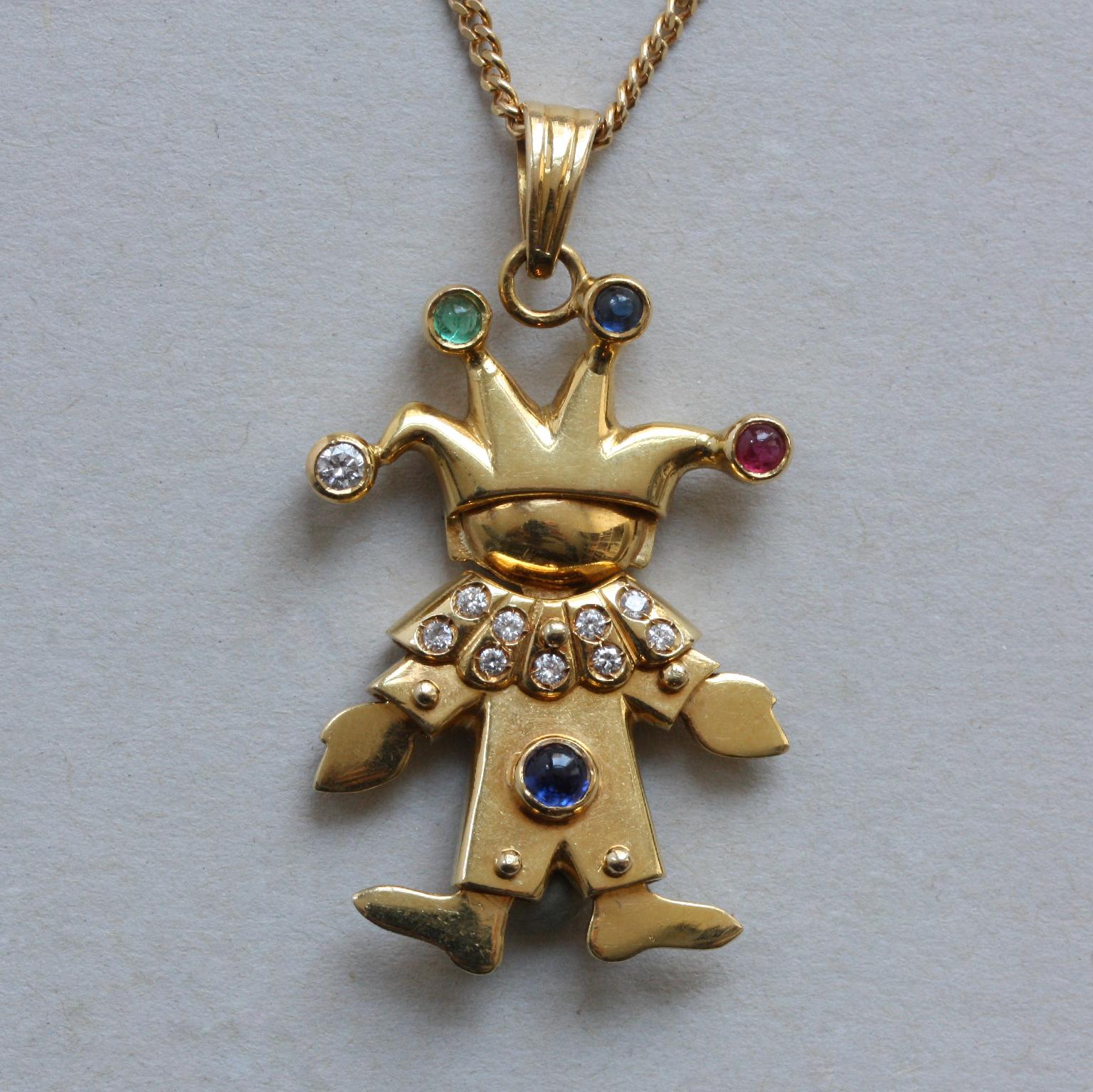 An 18 carat yellow gold articulate pendant on a chain, pendant in the shape of a clown is set with tien round brilliant cut diamonds (app. 0.1 carat in total), one cabochon cut ruby (app. 0.08 carat), one cabochon cut emerald (app. 0.06 carat) and