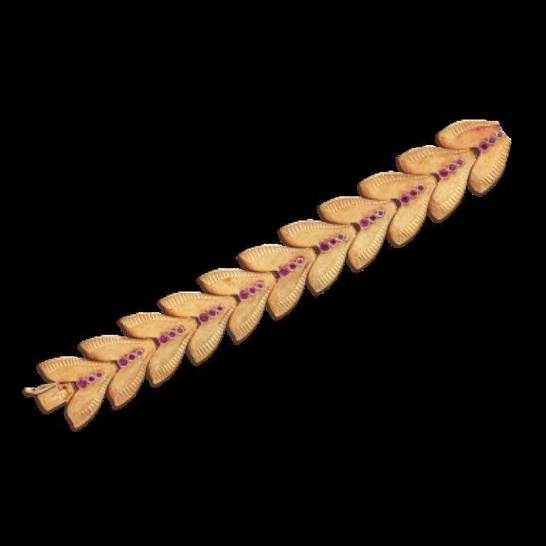 Comprising chevron links, set with round rubies.
 - Rubies weighing a total of approximately 2.65 carats
 - 18 karat yellow gold 
- Length 7 inches, width 1 inch 
- Total weight 85.75 grams
 - French 