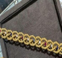 A 18 kt Yellow gold and diamond bracelet accompanied with sapphires and rubies