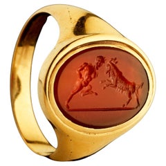Anillo de sello de 18 quilates engastado con un grabado de cornalina Grand Tour. Pan luchando contra una cabra.