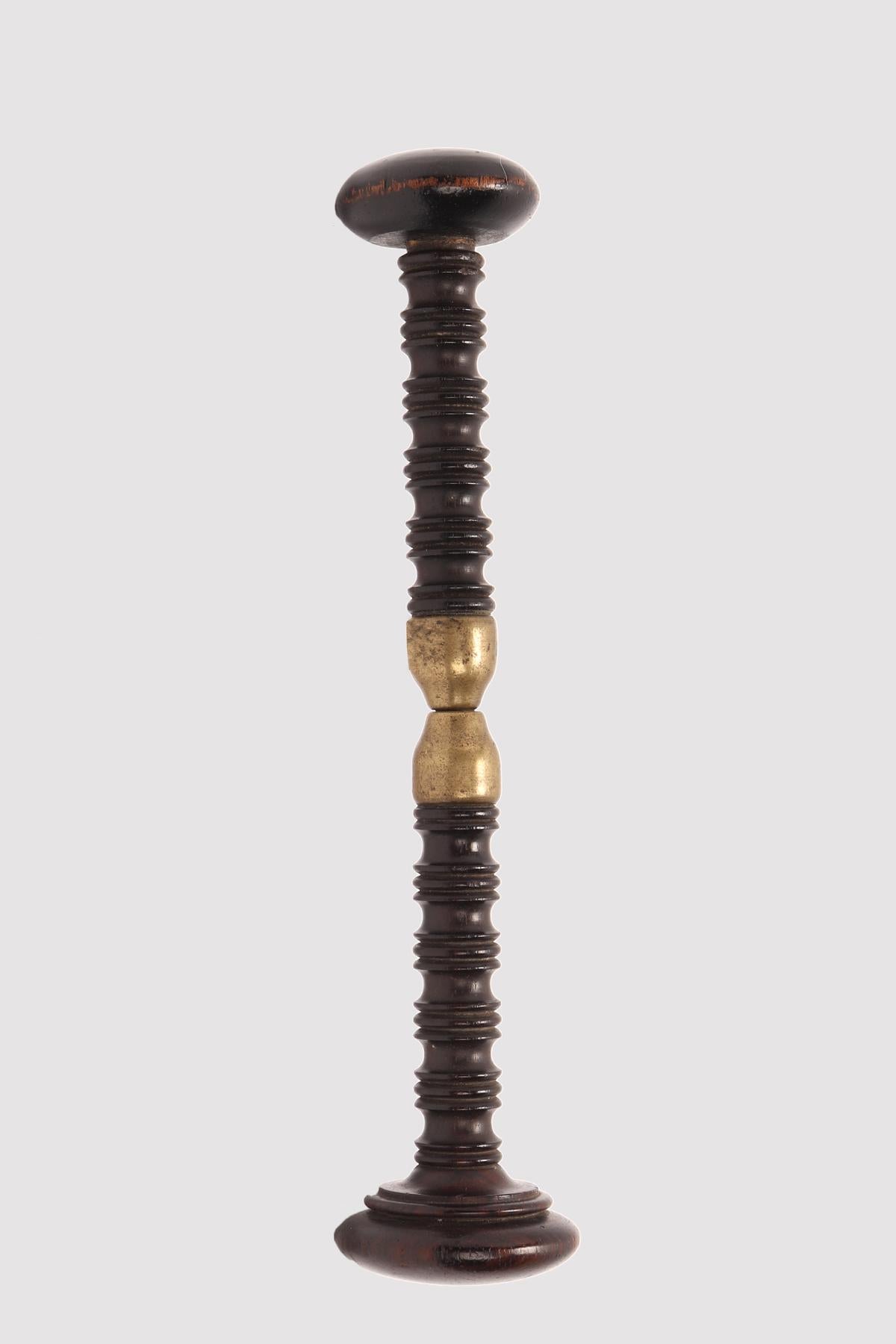 Un instrument médical. Une pince à vis (dilatateur) en laiton, avec un manche en bois de rose. Il se compose de deux parties symétriques, chacune avec un élément de coussin circulaire qui se poursuit par un corps cylindrique avec des groupes de