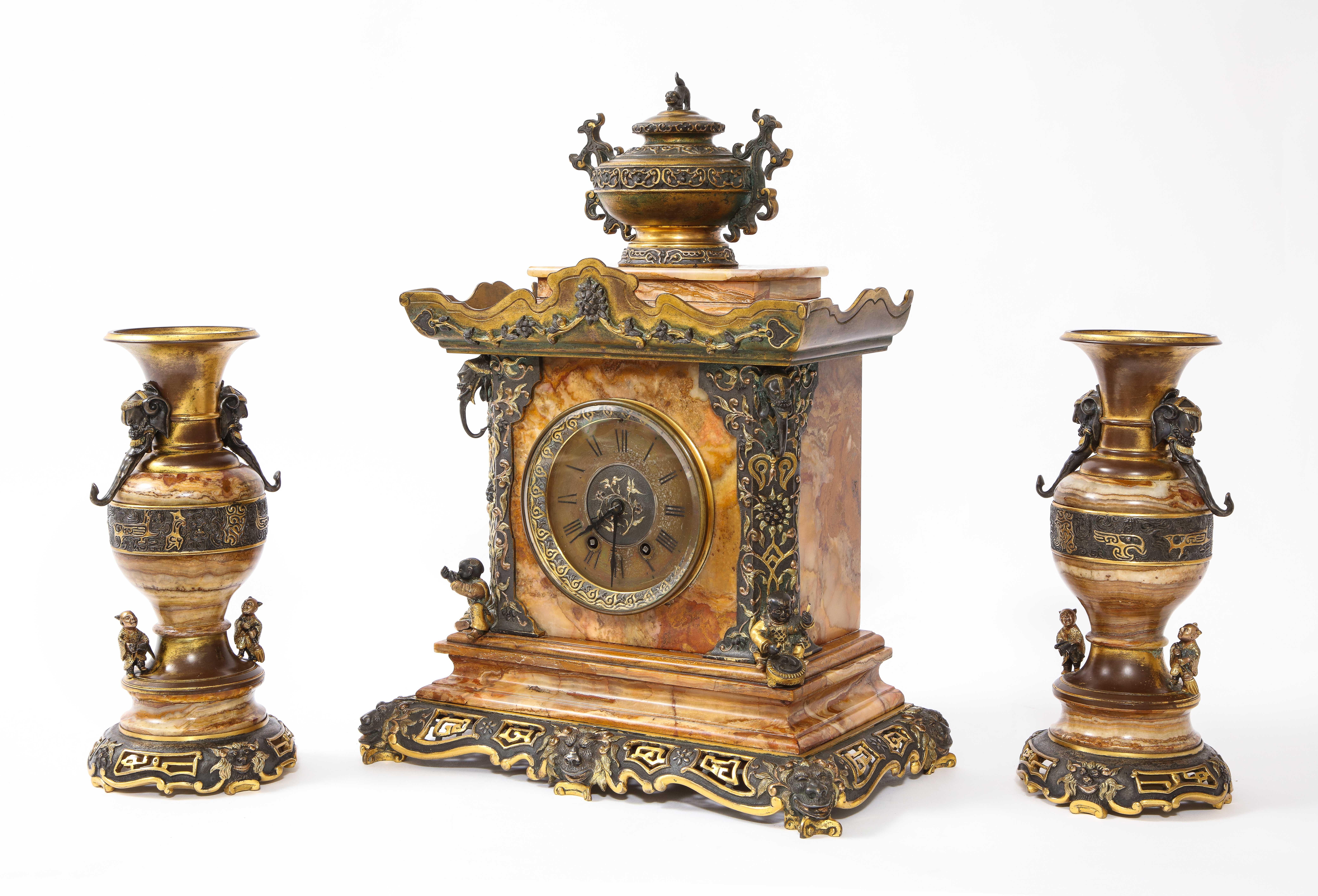 Juego de Reloj Japonisme Francés del Siglo XIX de Tres Piezas Atribuido a Eugène Cornu, en el Estilo de Édouard Lièvre. Consta de un reloj de chimenea y un par de jarrones a juego. El conjunto está construido en bronce patinado y dorado con