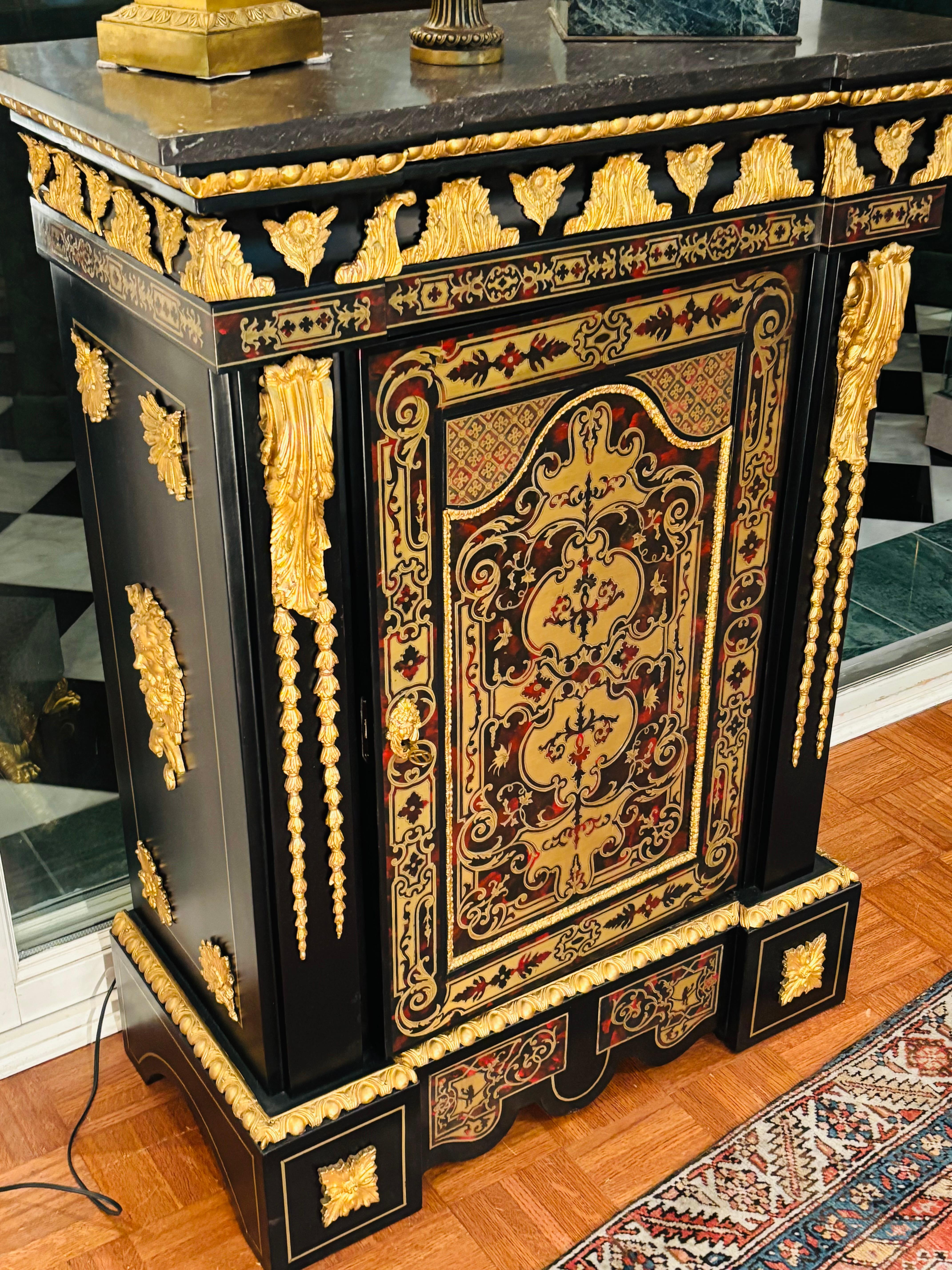 A french Louis XVI style  grey marble topped Meuble d'Appui after a model by  Mathieu Belfort.The ebonized cabinet is inlaid with brass and has all-over lavish gilded bronze mounts and mouldings. The front door opens to reveal a shelved  oak