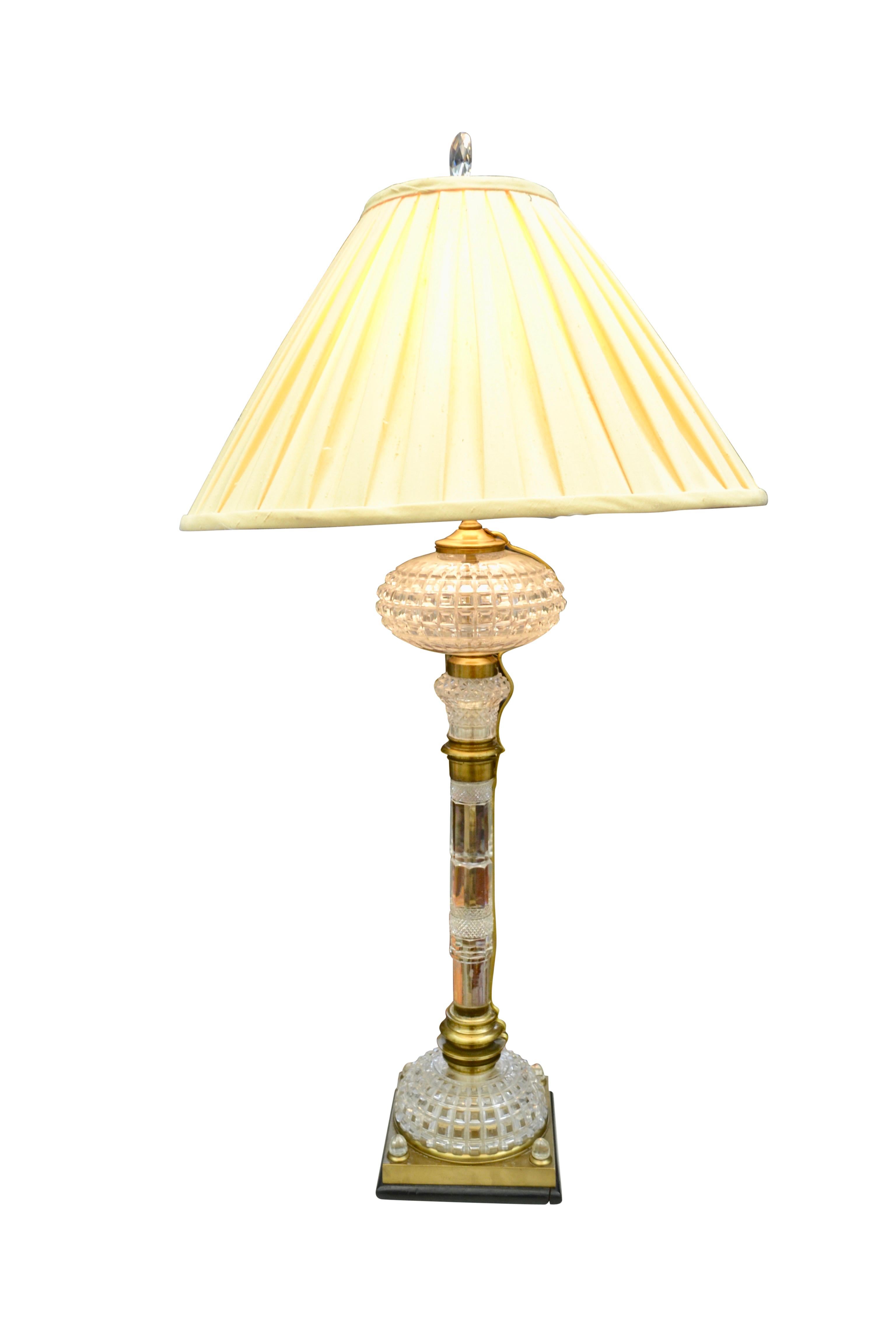 Une lampe à huile en cristal taillé de la fin du XIXe siècle, désormais électrifiée. Heureusement, le câblage est extérieur, il n'y a donc aucun dommage à la lampe d'origine. La colonne en cristal et en laiton repose sur une base en cristal