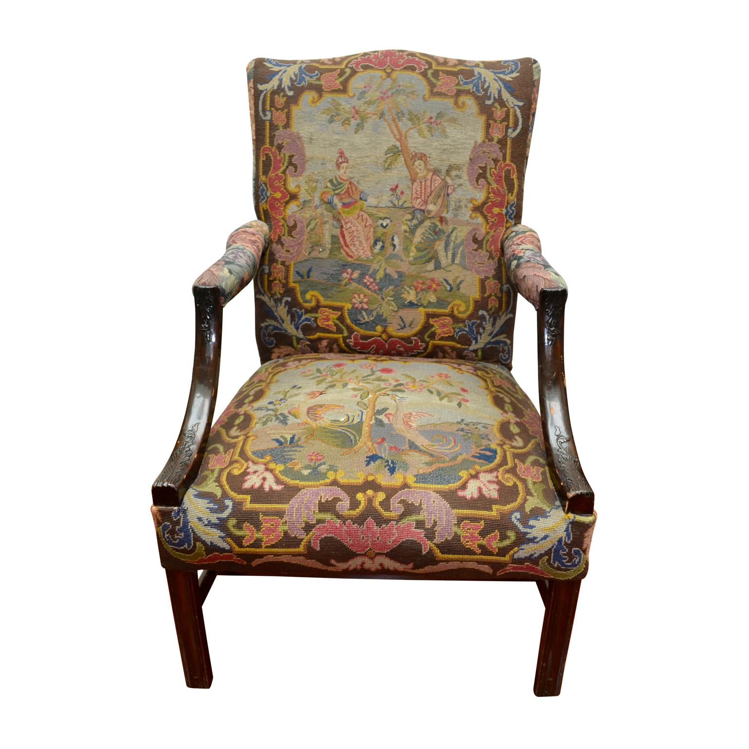 An English Chippendale style library chair with the seat and inside back upholstered in gros and petite point needlework in an oriental theme. The chair back is slightly camel shaped; the outside back of the chair is upholstered in an oyster colored
