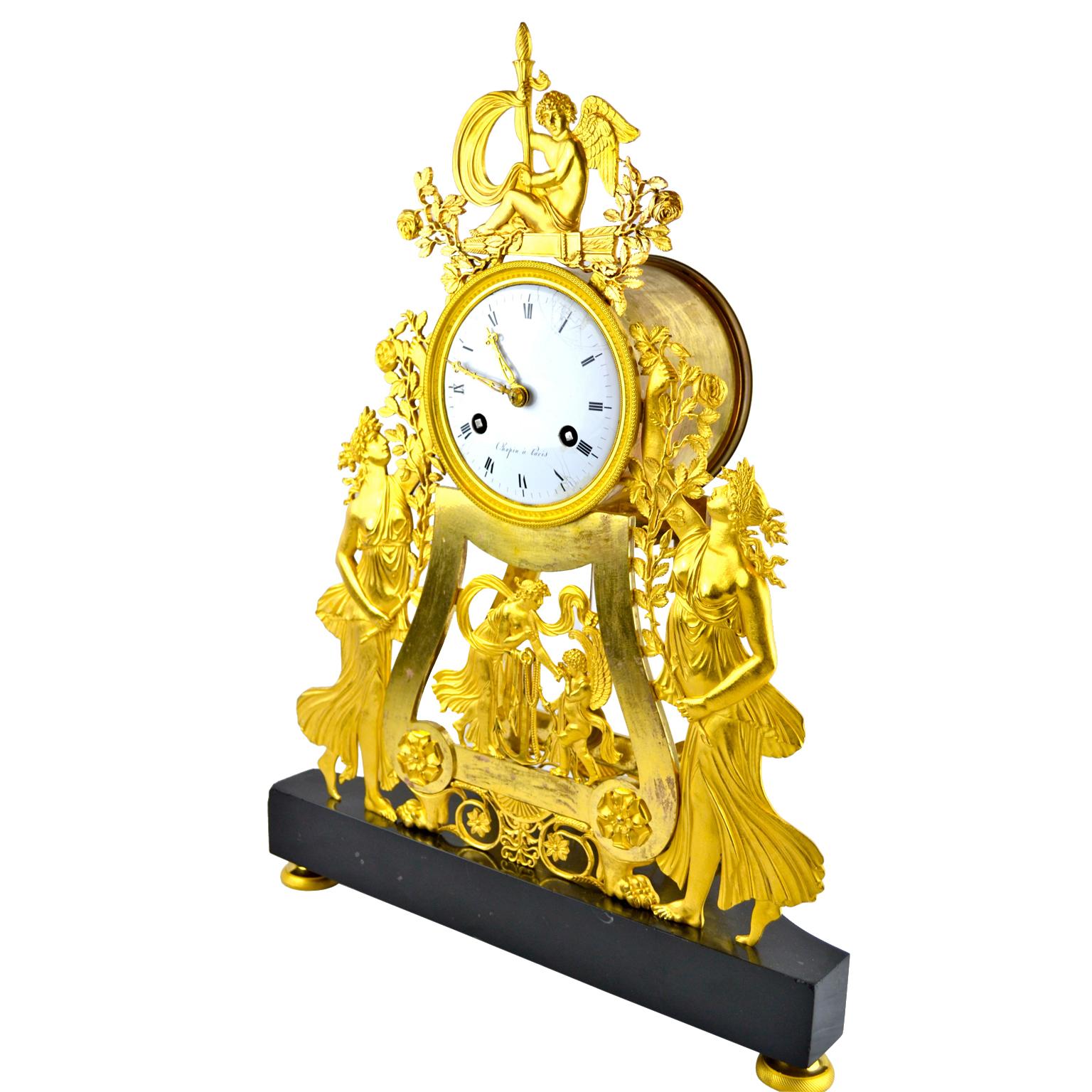Orologio classico bidimensionale a scheletro dell'Impero francese, la cassa finemente cesellata e dorata al mercurio raffigura Amour che regge una torcia fiammeggiante e uno stendardo, simbolo di guerra, seduto su una faretra piena di frecce e