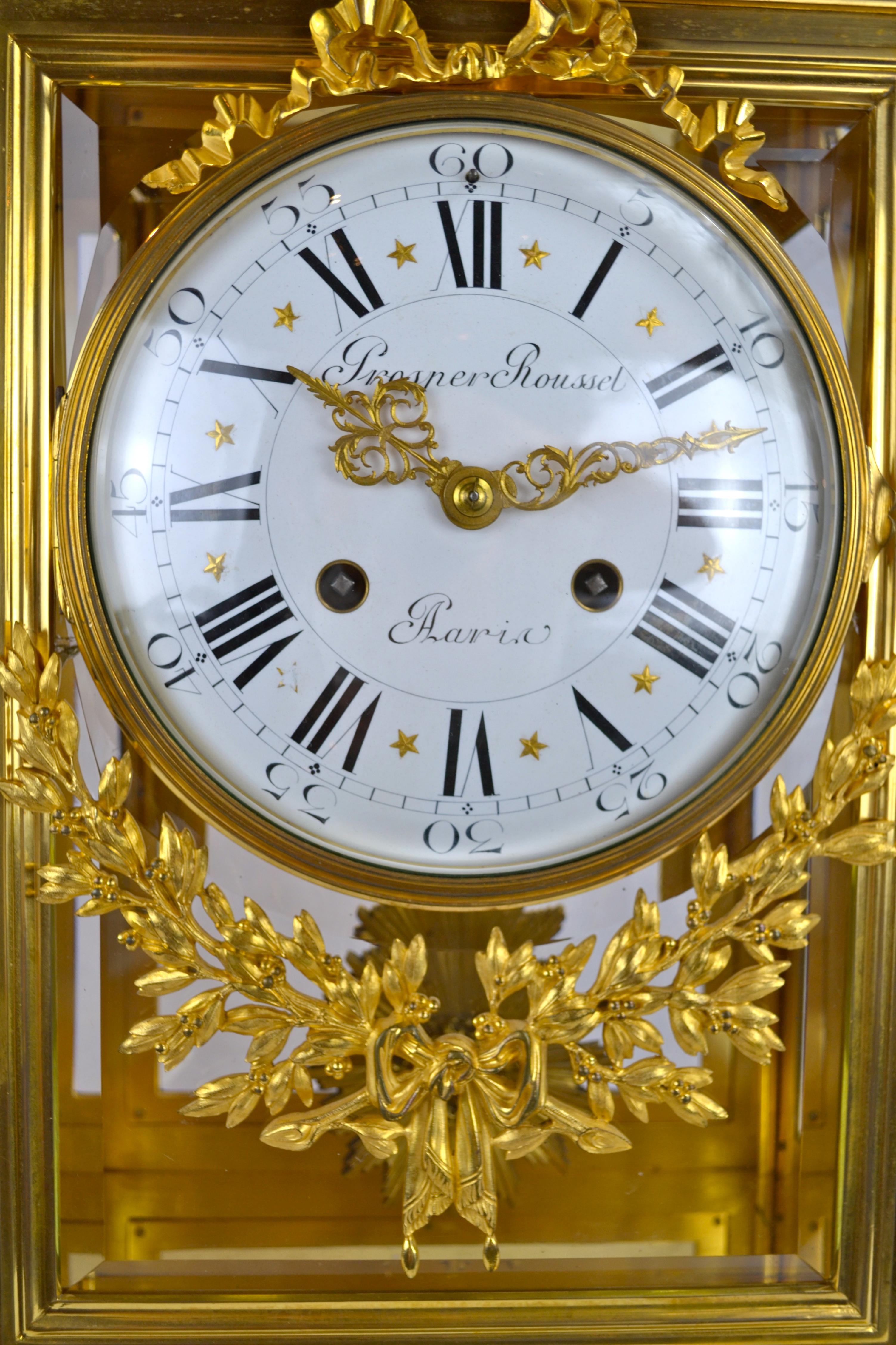 A French Louis XVI style gilt bronze regulator clock, the finely cast rectangular case with four beveled glass sides; the large white enamel dial with Roman numerals is decorated above and below with gilt bronze garlands. The dial is signed Prosper