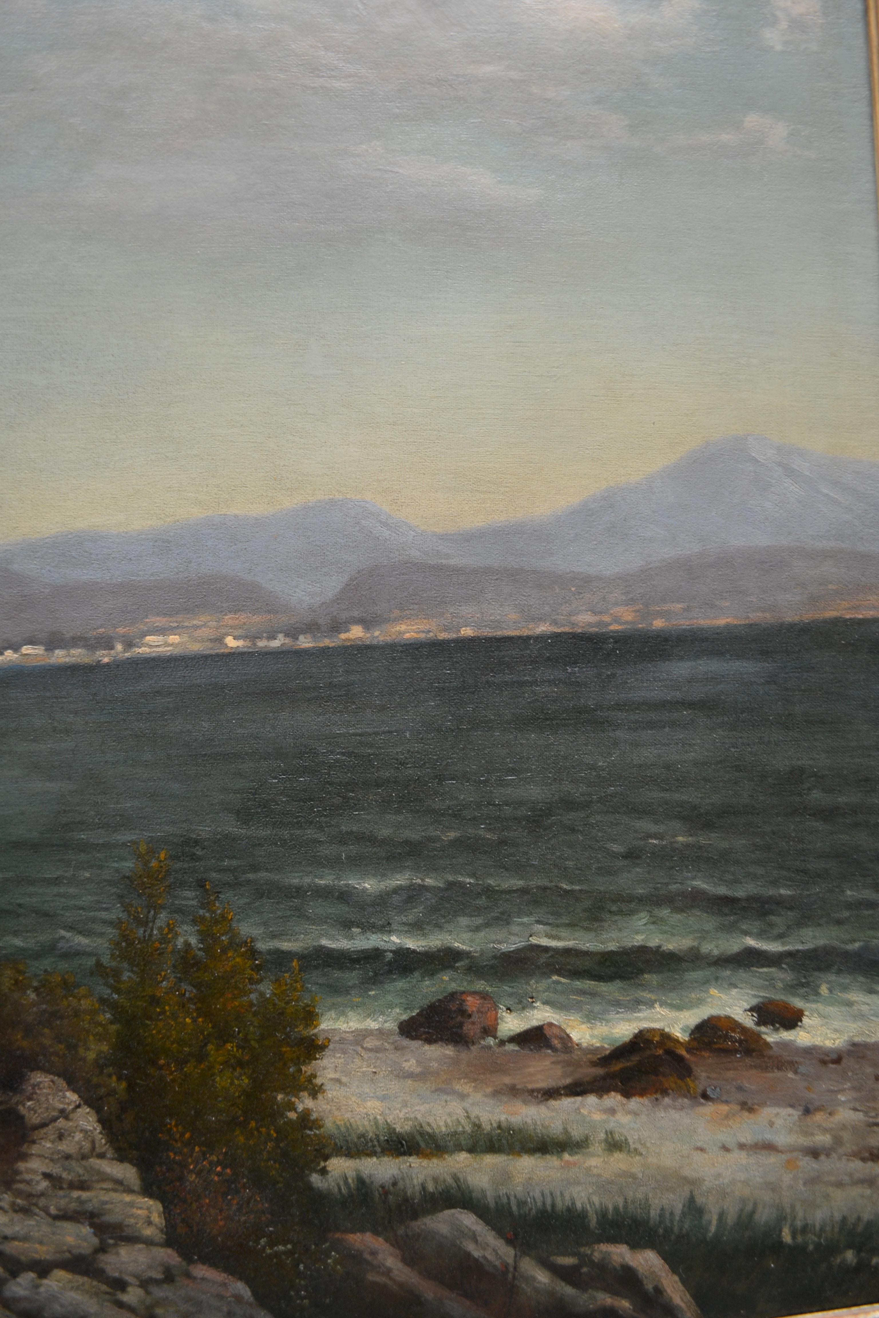 A large oil on canvas of a Northern Italian lake landscape showing part of the shoreline of Lake Como with a tiny village on a peninsula jutting out the lake as it was in the late 19th century by Austrian landscape artist Karl Kaufmann. Signed