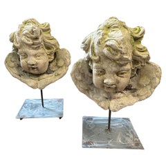 Ein Paar italienische Jugendstil-Engelköpfe aus Steinstaub auf einem modernen Eisensockel aus dem Jahr 1900