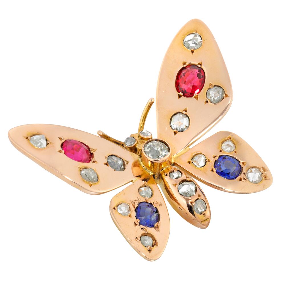 A 1900s French ruby and sapphire gold butterfly brooch, the butterfly set with oval faceted rubies on the forewings, estimated to weigh a total of 0.7 carats, and oval faceted sapphires on the hind wings, estimated to weigh a total of 0.45 carats,