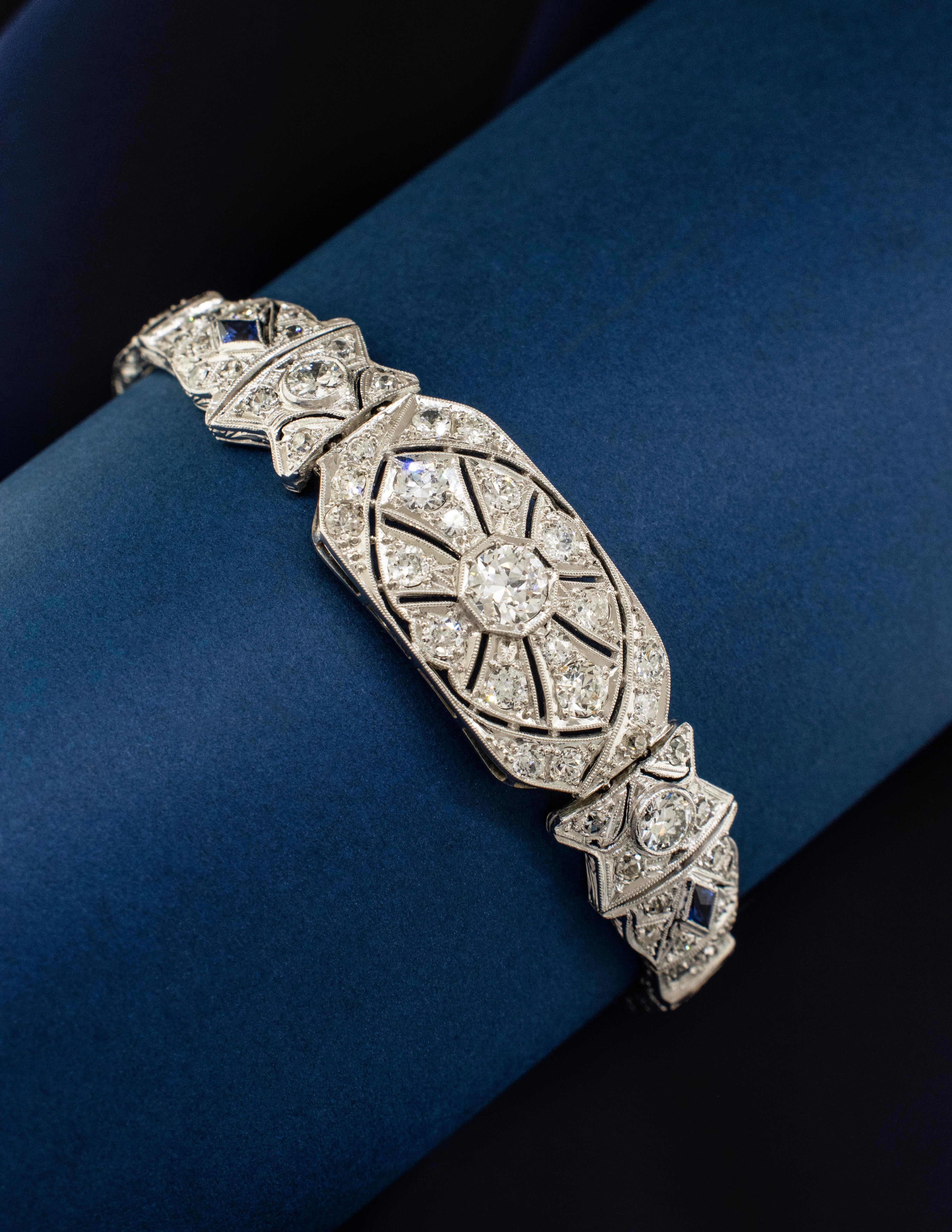 A 1920's Art Deco Platinum bracelet with diamonds and sapphire accents. There are 80 Old European Cut Diamonds weighing approximately 4.75 carats. The diamonds are original to the bracelet. The center diamond weighs approx. 0.55 carats. The two