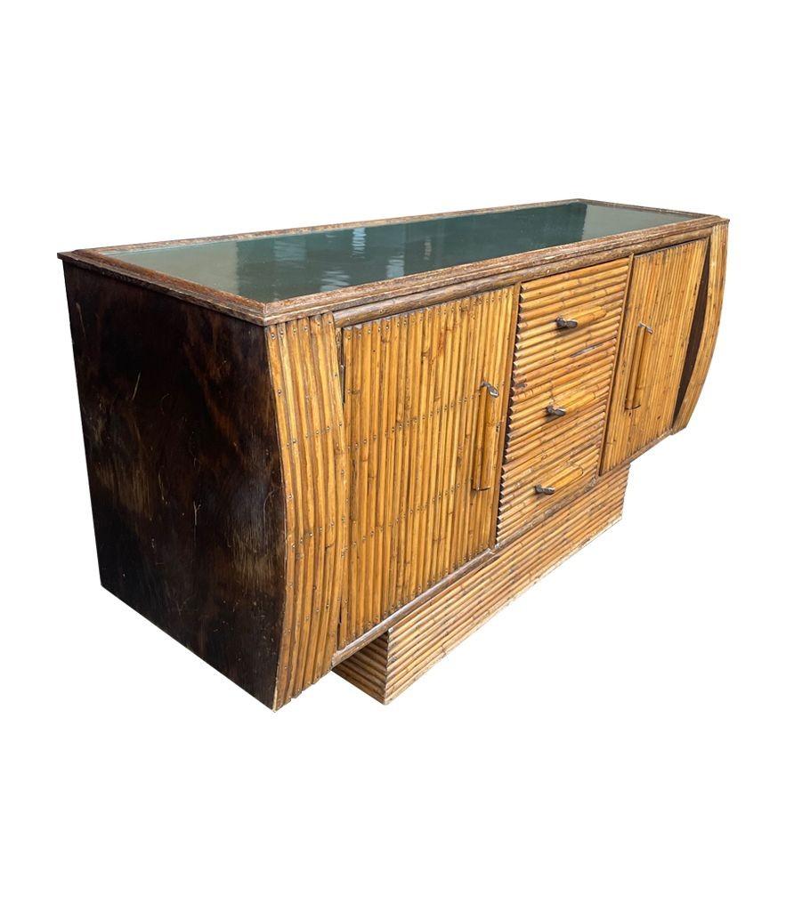 A 1920s oak and bamboo sideboard by Angaves of Thurmaston Nr Leicester with two doors and three drawers. The top has the orignal frosted glass top, which could be replaced with a coloured glass if required. Mounted on plinth base with orignal label