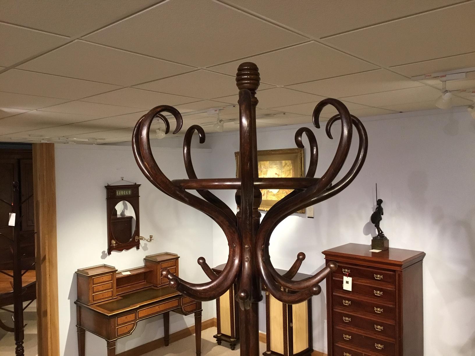 A 1920s period bentwood hat, coat and umbrella stand. The upper section having eight bentwood hat and coat hooks, the lower section with four umbrella/walking stick divisions with swept bentwood feet. Austrian circa 1920

Dimensions: 86