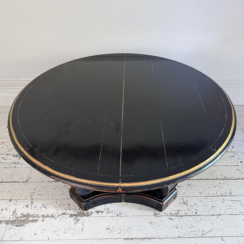 Un superbo tavolo da pranzo allungabile in stile Regency, ebanizzato e dorato, acquistato da Liberty e che riprende magnificamente la maestria e l'estetica della Maison Jansen. Questo tavolo elegante e altamente funzionale incarna il raffinato