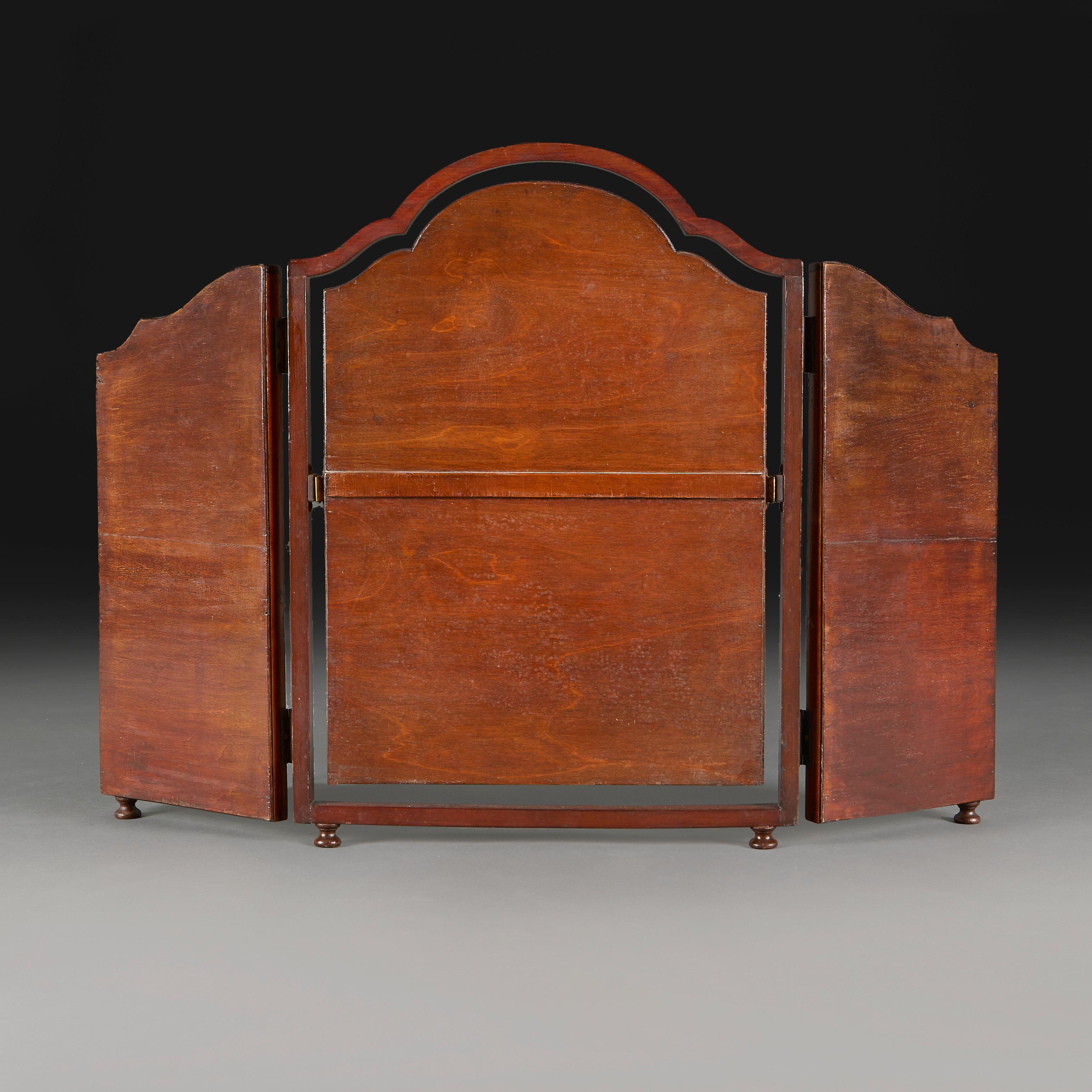 A 1920s Danish dressing mirror, the triptych frame with arched walnut borders, adjustable central mirror plate, all supported on bun feet.