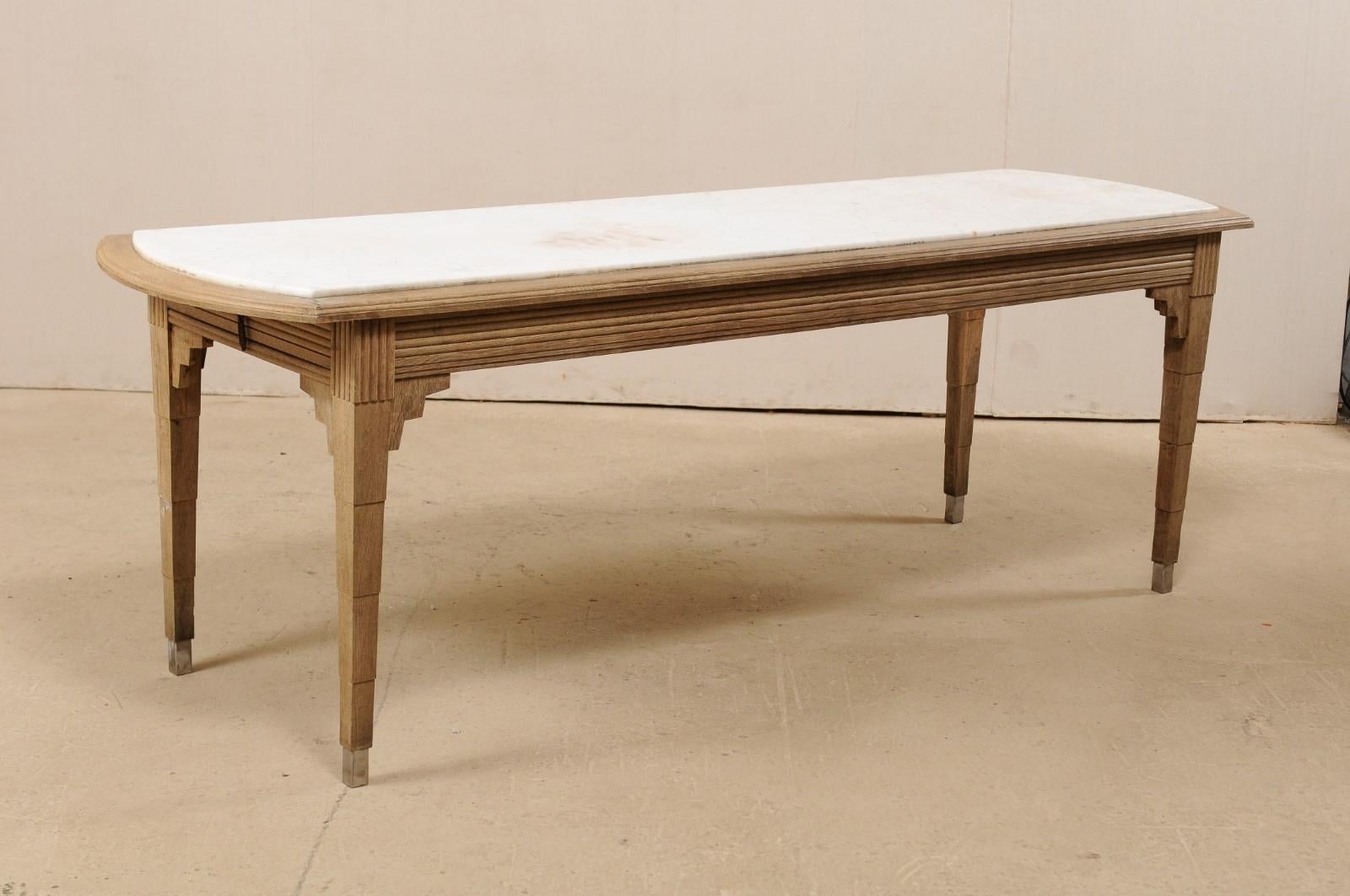 A French slender-sized table with marble top, perfect for a kitchen island, circa 1930s. This antique Art Deco table from France features an elongated rectangular-shaped top, with arched ends, set with white marble. A single drawer is housed at