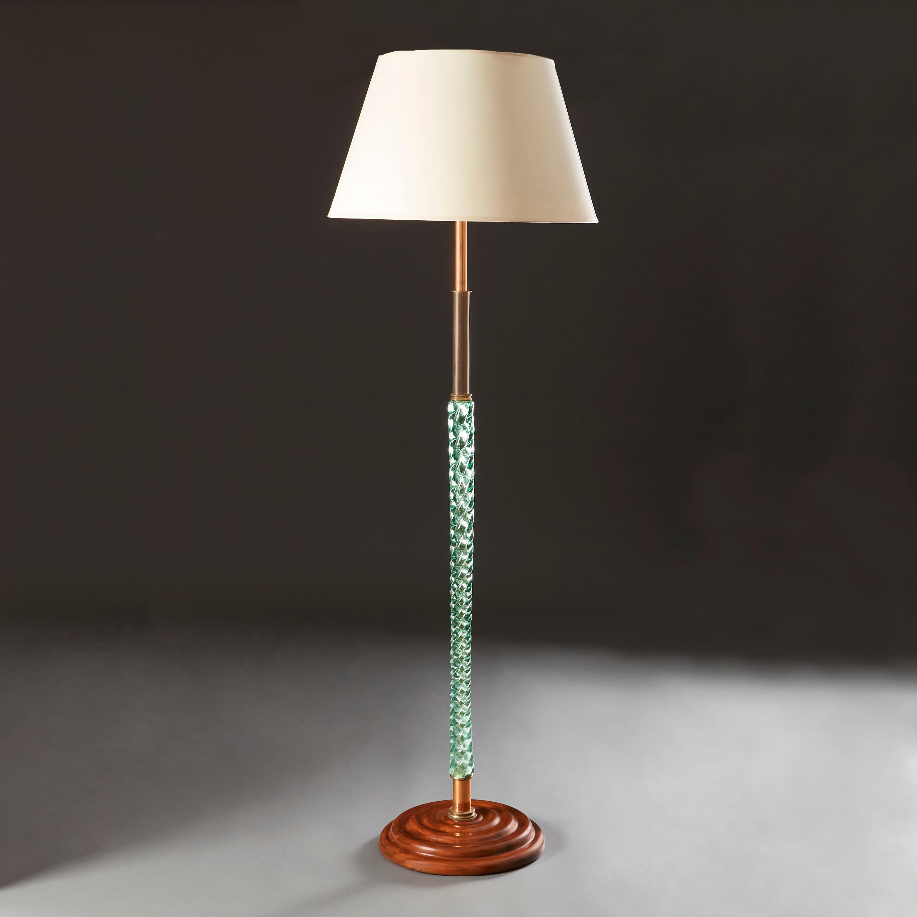An unusual early twentieth century standard lamp, the stem made up of green-tinted twisted glass, topped with copper metalwork, all supported on a stepped, turned mahogany base. After Venini.

Currently wired for the UK.

Please note: Lampshade