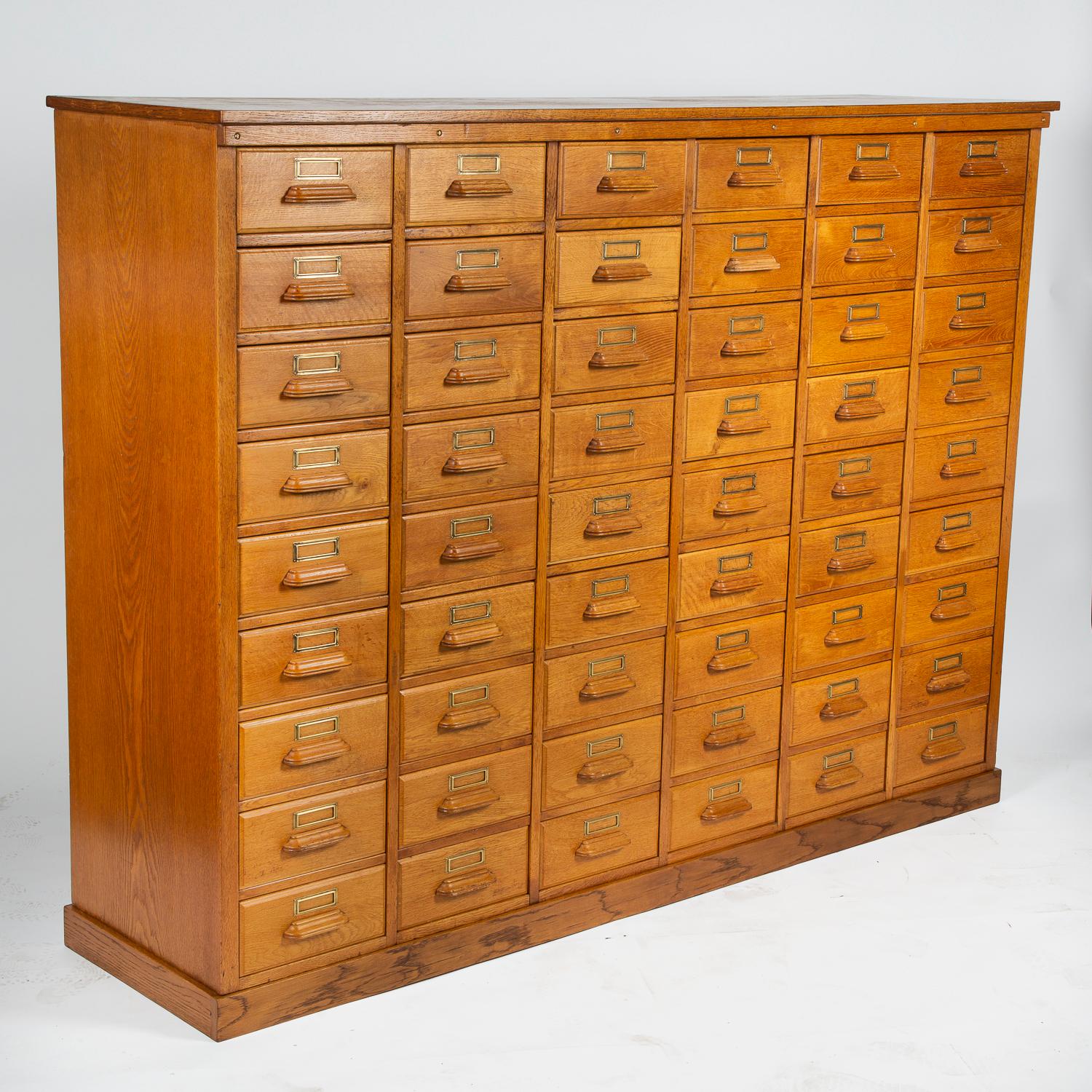 A golden oak haberdashery or shirt maker’s cabinet, with brass label holders. 

54 Drawers, each drawer has the right hand side cutaway for access.

Drawers comfortably fits US letter and A4 size paper, the internal dimension of each drawer is
