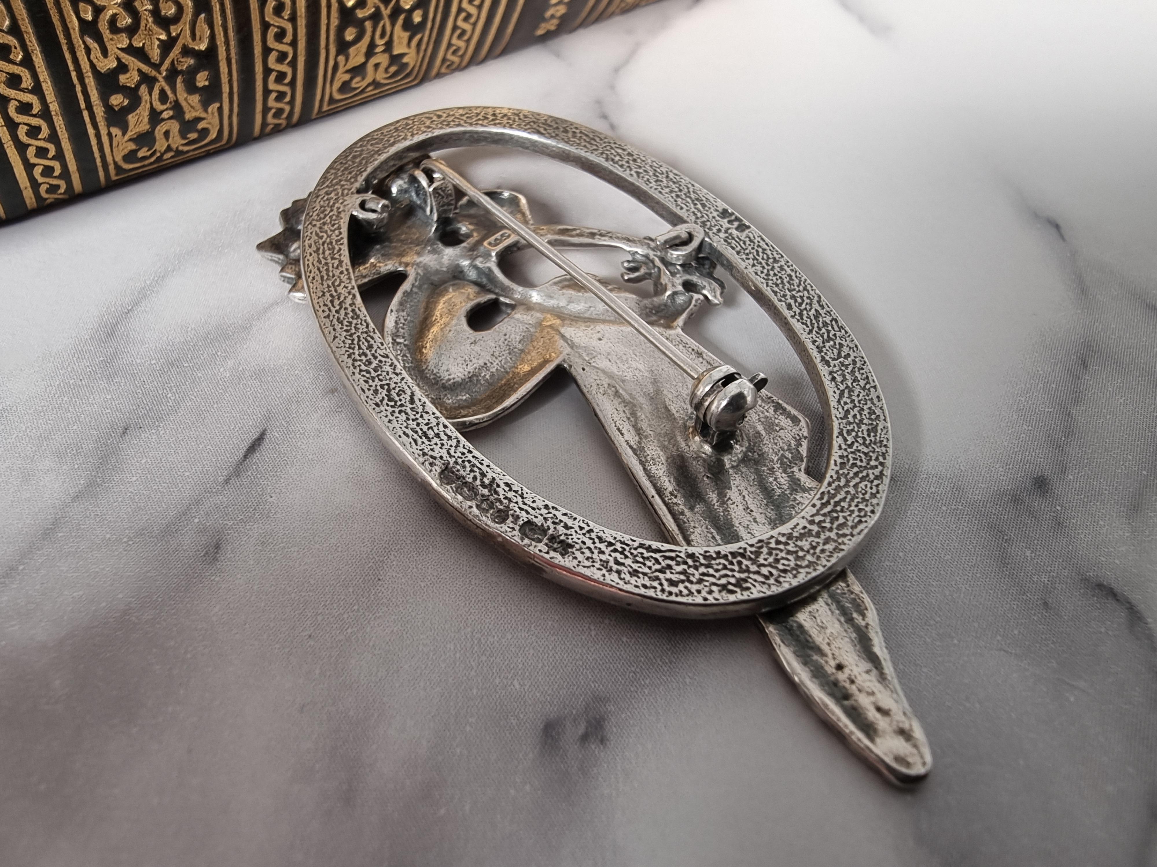 Eine sehr gut gemachte kontinentale Silberbrosche aus den 1930er Jahren. Im Zentrum dieses sehr dekorativen Stücks steht die fein gegossene Figur einer sitzenden Fee, die einen Blumenstrauß hält. Sowohl ihre Flügel als auch der Strauß sind mit