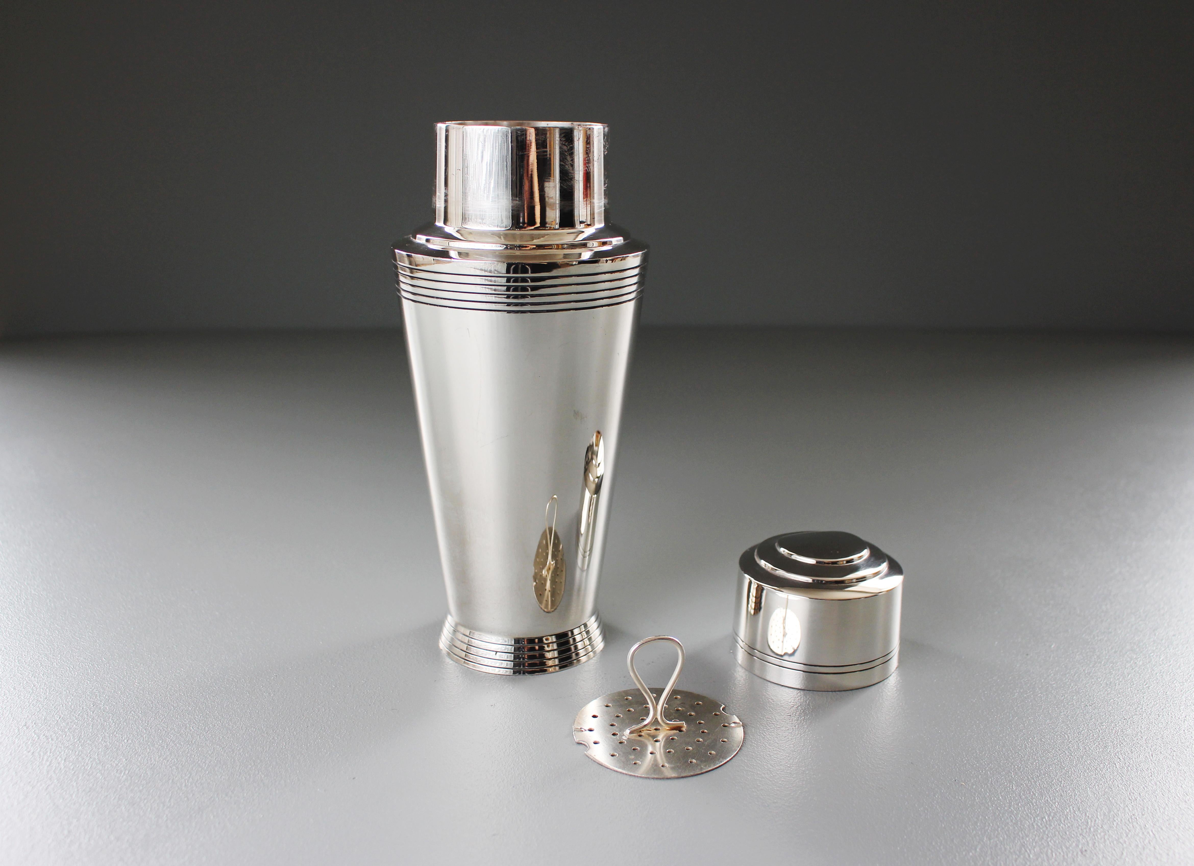 An electroplated cocktail Shaker designed by Keith Murray for Mappin and Webb, circa 1930, model no W27731, flaring cylindrical form with reeded flaring foot and band to shoulder, with stepped cover and internal strainer, stamped marks underneath.